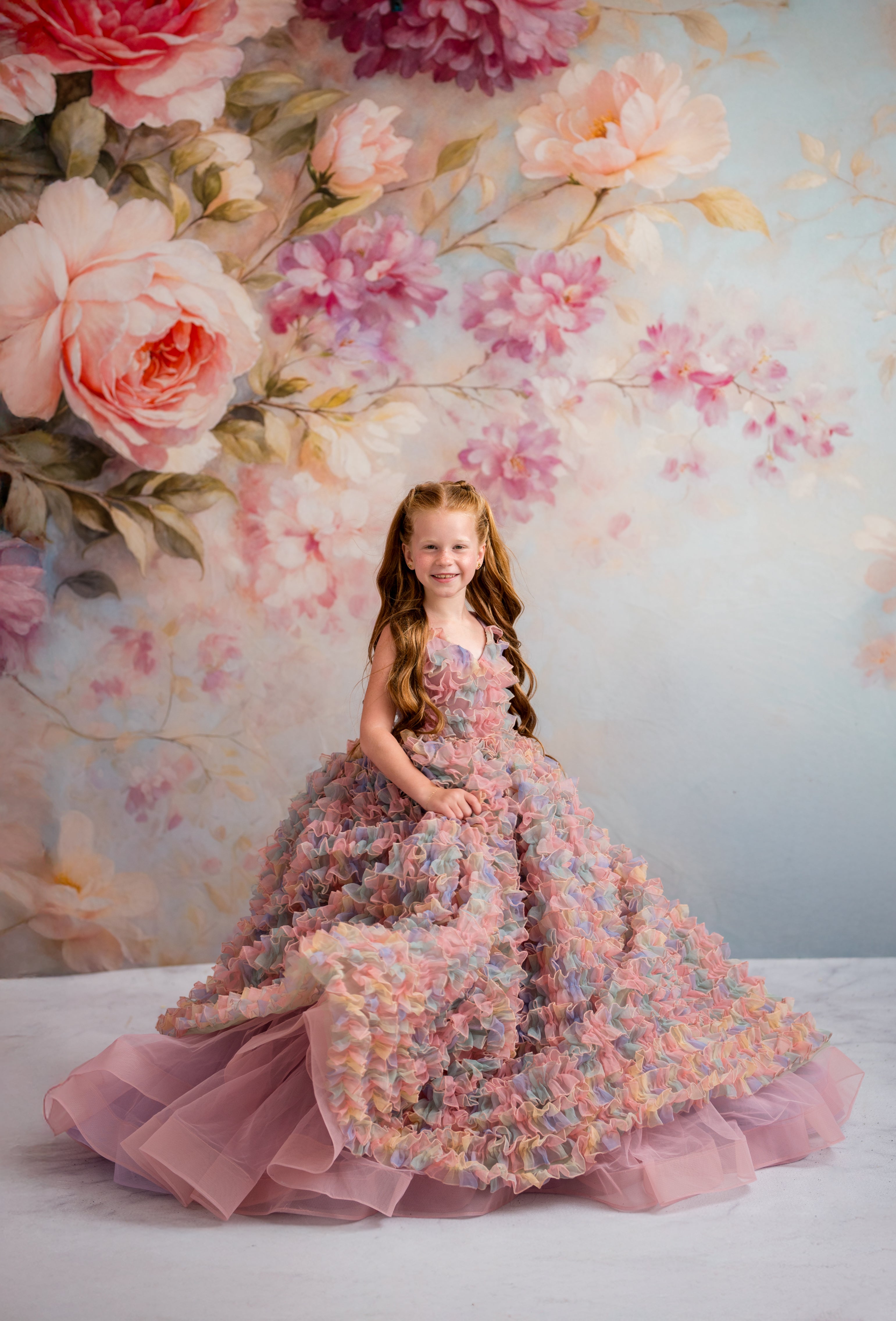 Young girl in a floral dress against a floral backdrop