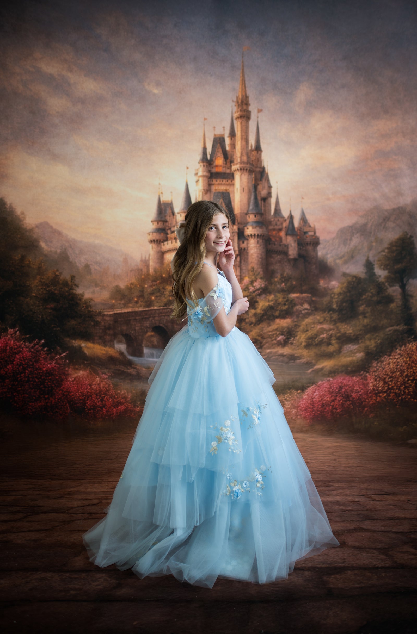 Woman in a light blue dress standing in front of a castle with a fantasy landscape.