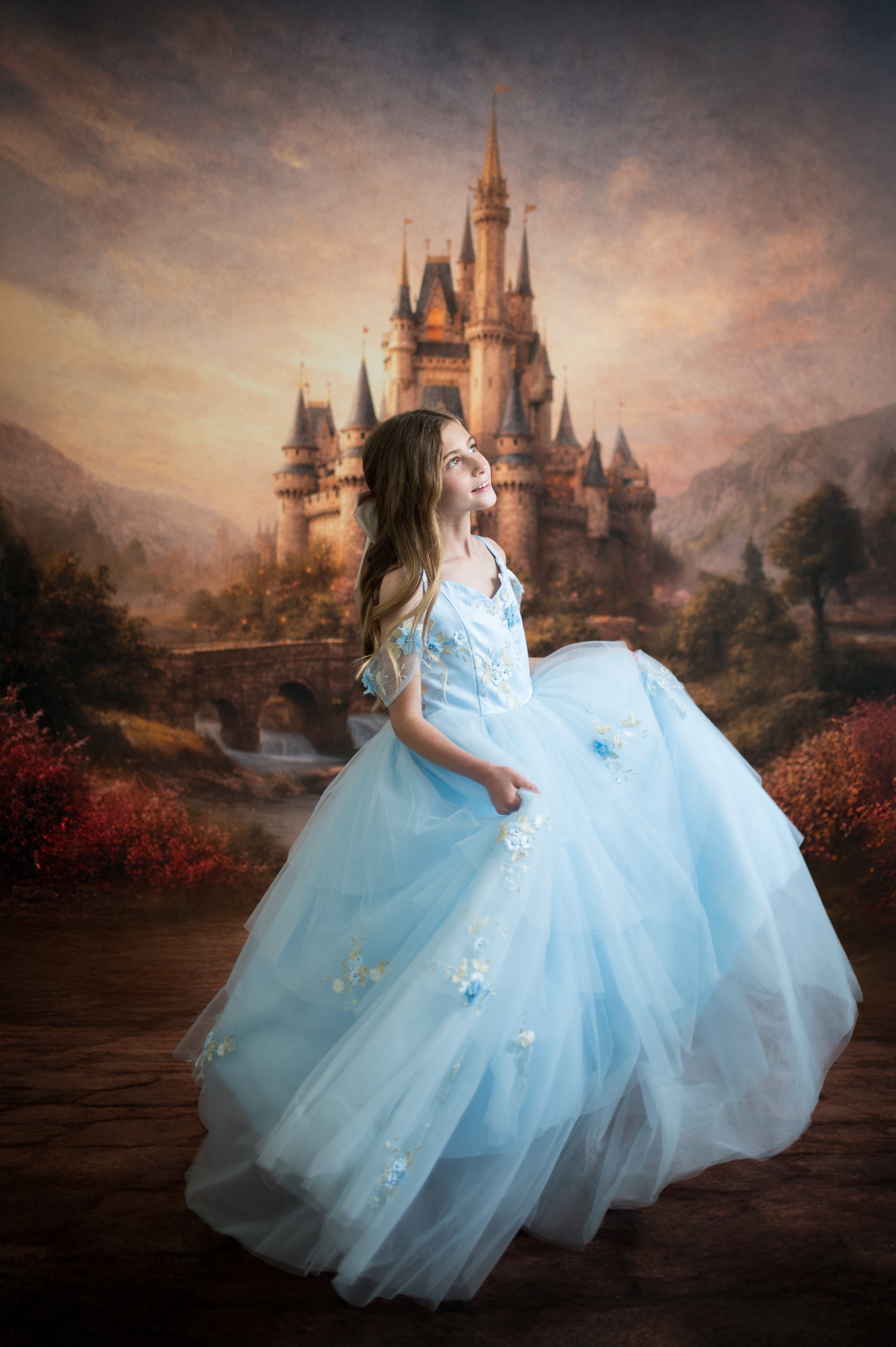 Woman in a blue dress standing in front of a fantasy castle