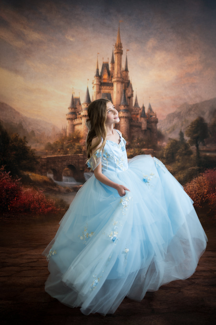 Woman in a blue dress standing in front of a fantasy castle