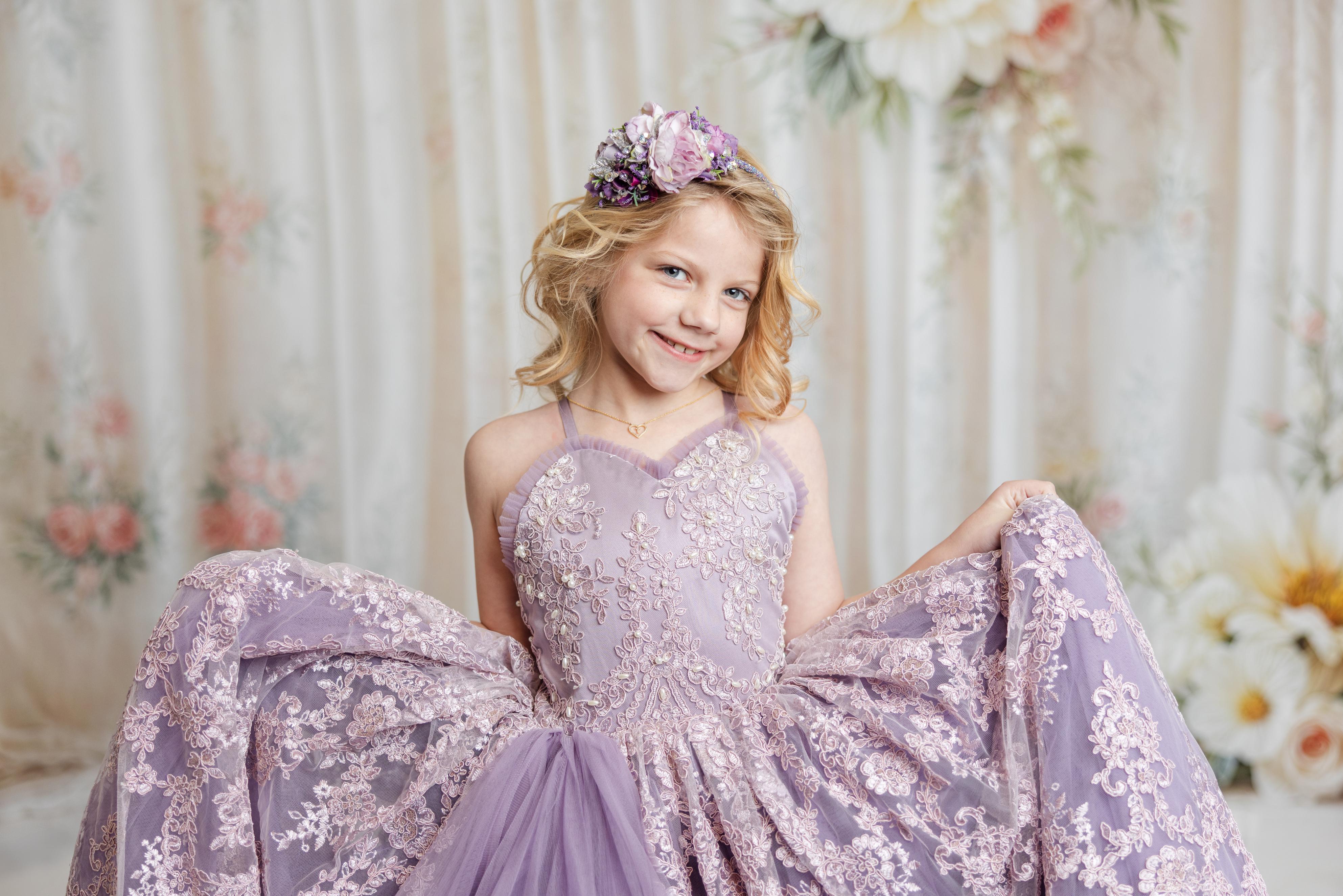 Styled children’s photography session with girl posing in a pastel designer gown

