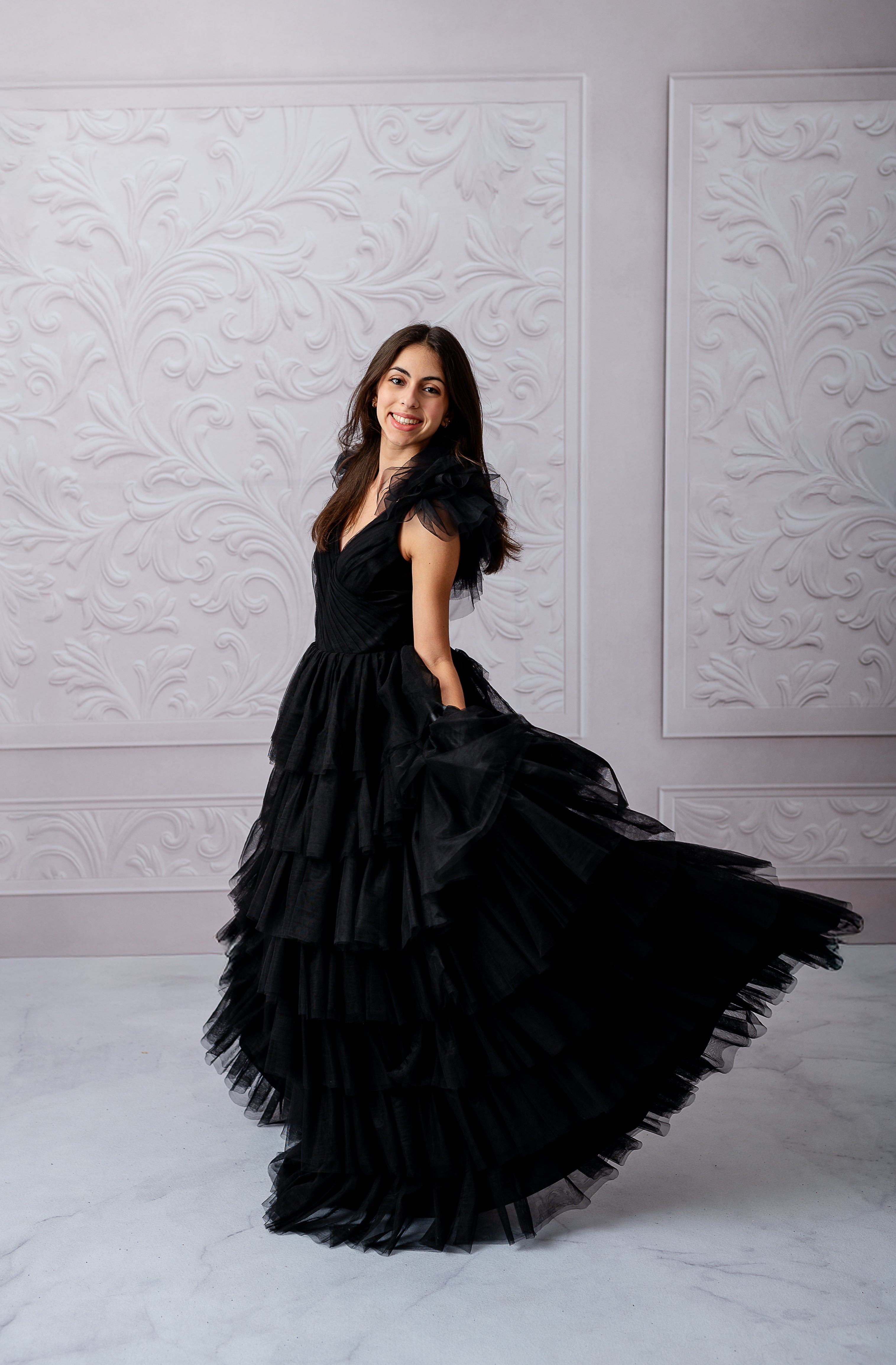 Noir Reverie gown featured against a textured white wall backdrop.