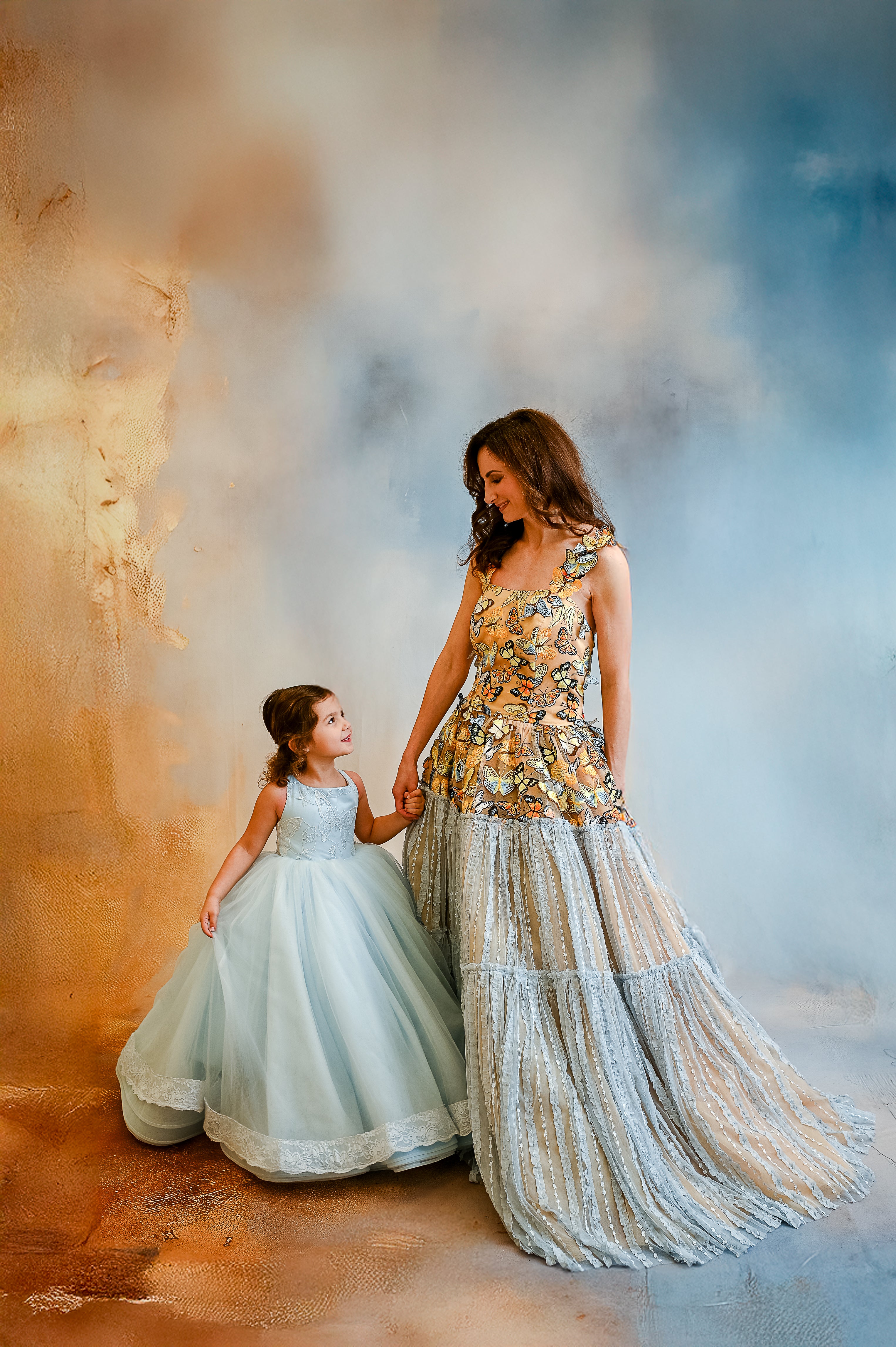 mom and daughter wearing coordinating gowns with butterfly motifs