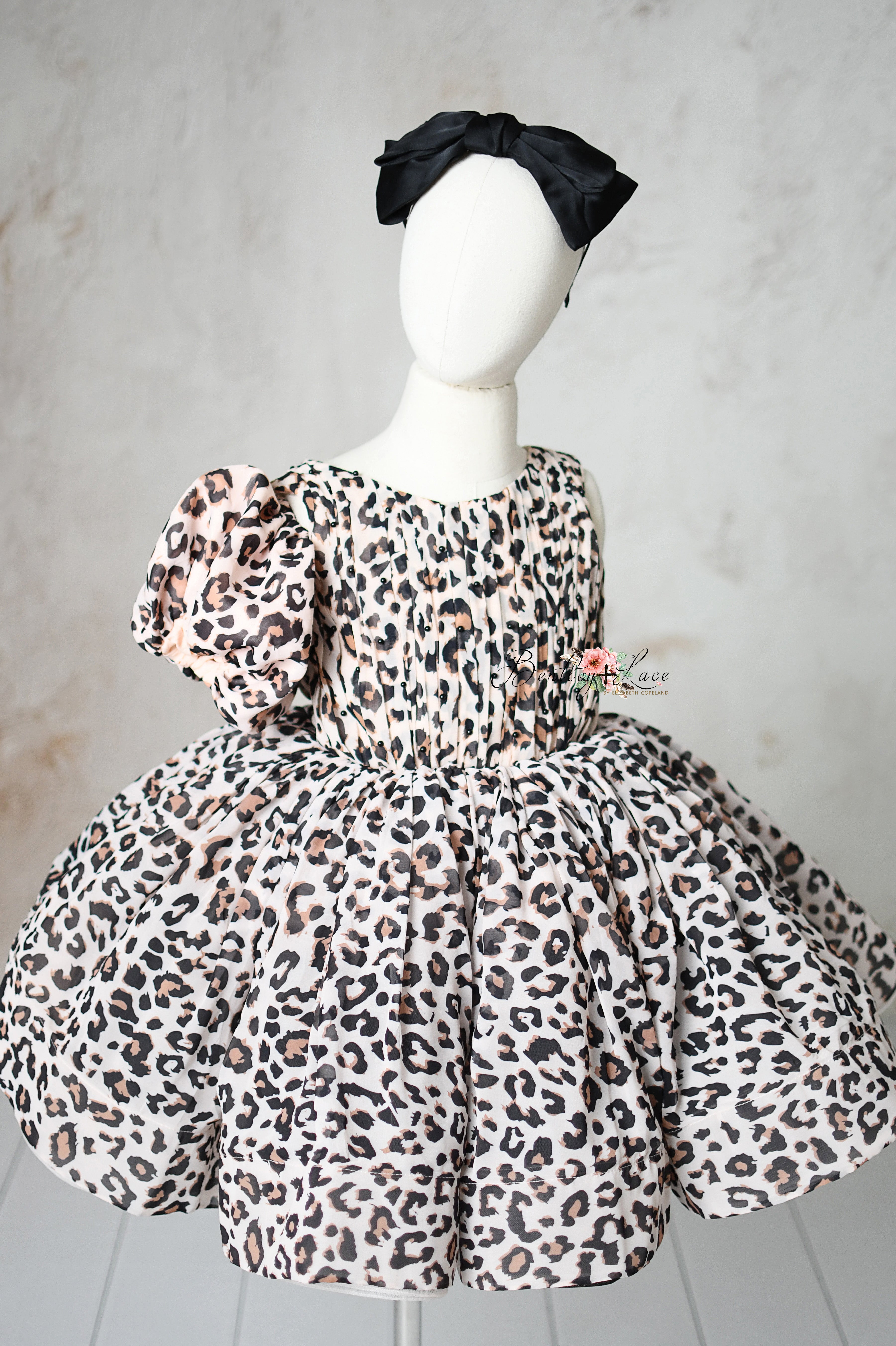 "Removable puff sleeves on a chic leopard print dress for 6 to 8-year-olds."
