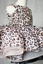 "Front view of toddler leopard print petal-length dress with adjustable ties and puff sleeves."
