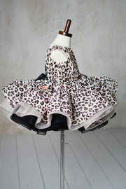 "Detailed view of puff sleeves and leopard print fabric on a toddler petal-length dress."
