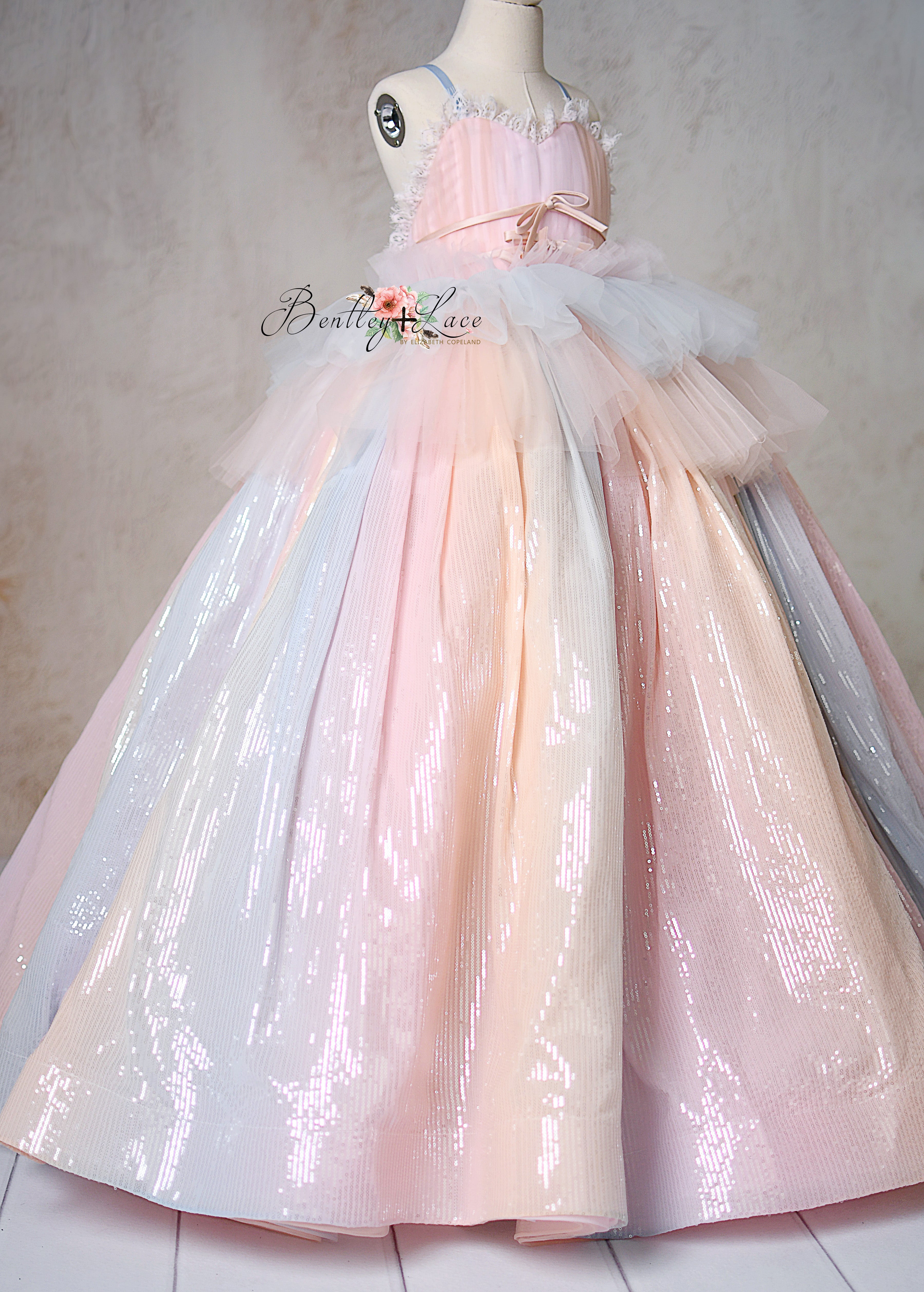 Shimmering pastel ombré gown with tulle layers on a mannequin.
