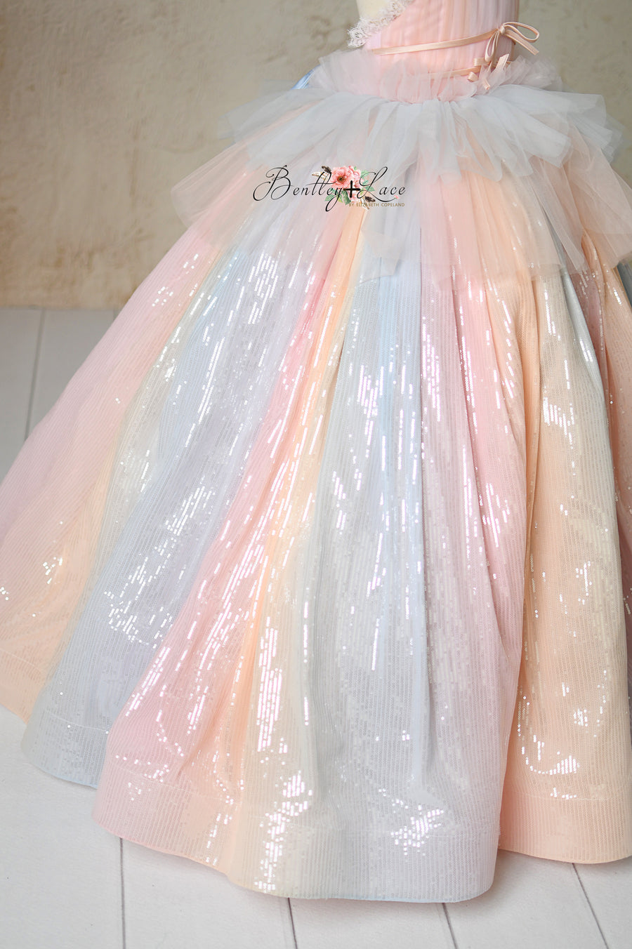 Ethereal gown with shimmering fabric, adjustable fit, and layered tulle.
