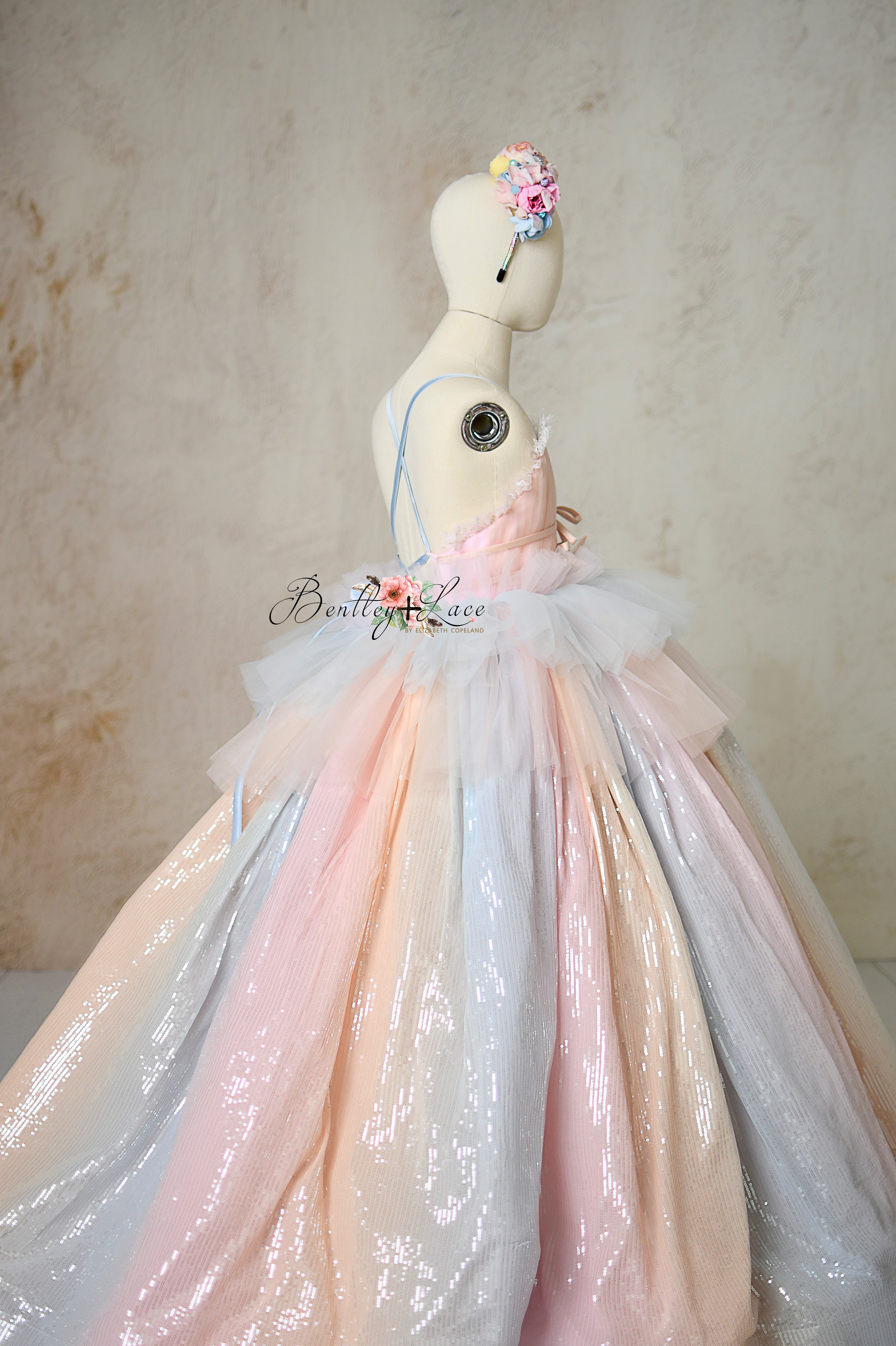 Elegant dress featuring pastel hues, hand-pleated tulle, and bow accents.
