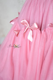 Luxurious pink formal dress with a dramatic train and layered skirt.
