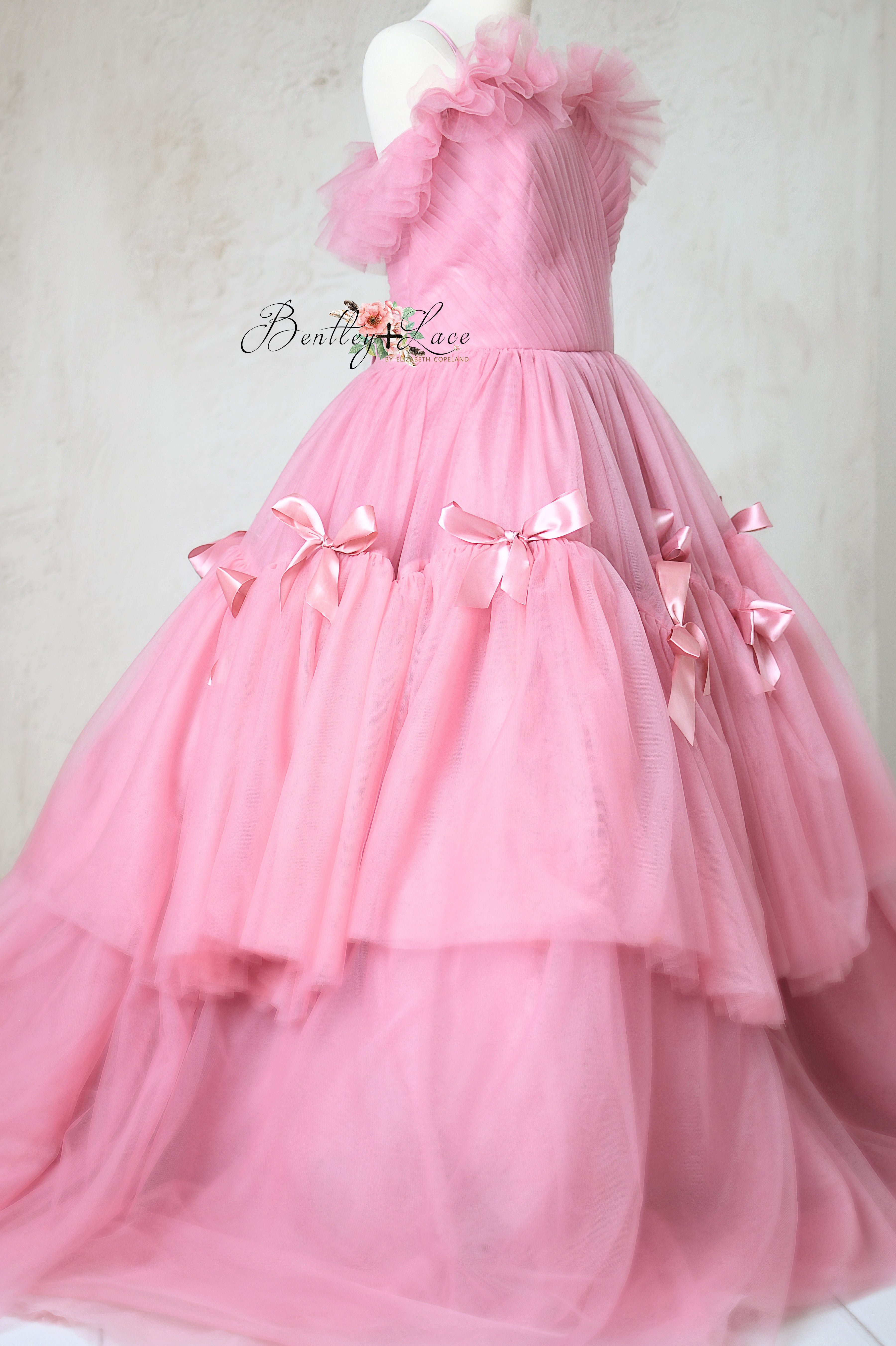 Soft pink tulle dress with a corseted back and adjustable shoulder ties.
