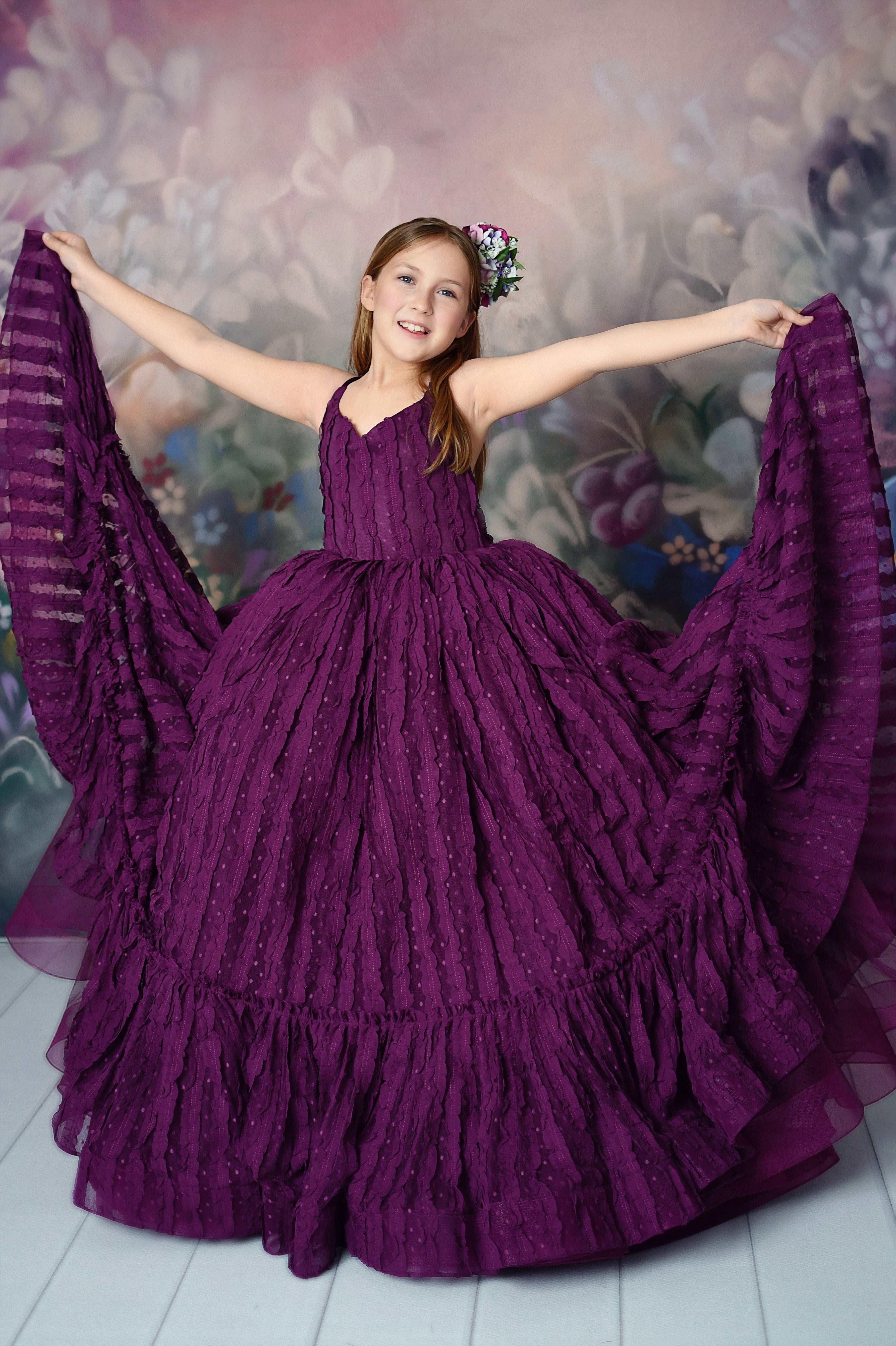 Young model wearing a luxurious orchid-colored dress, holding the fabric gracefully.






