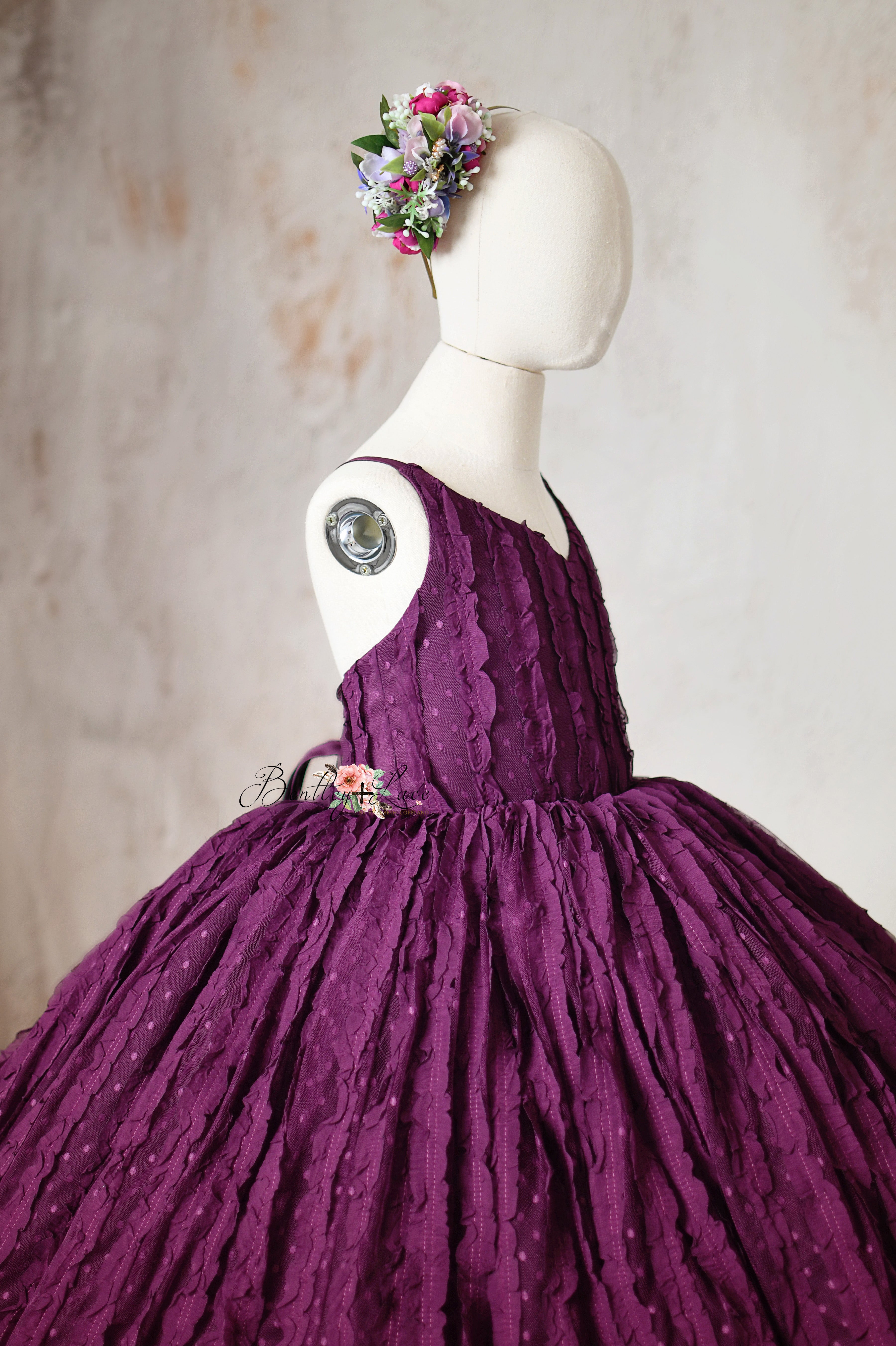 A vintage-inspired plum dress with a dramatic silhouette, perfect for photoshoots or formal events.
