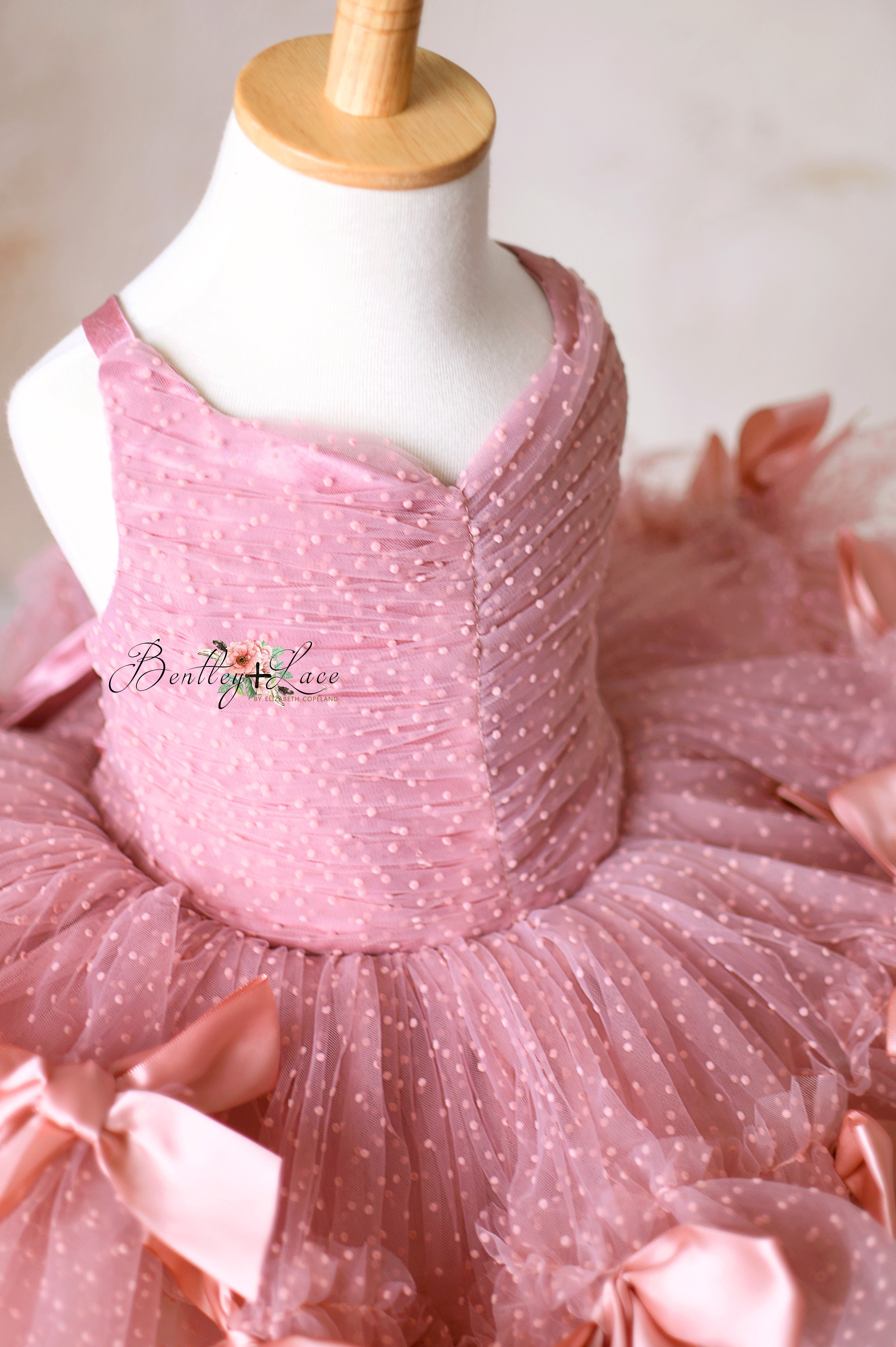 Handmade pink ballerina-style gown with soft dotted tulle and oversized satin bows.
