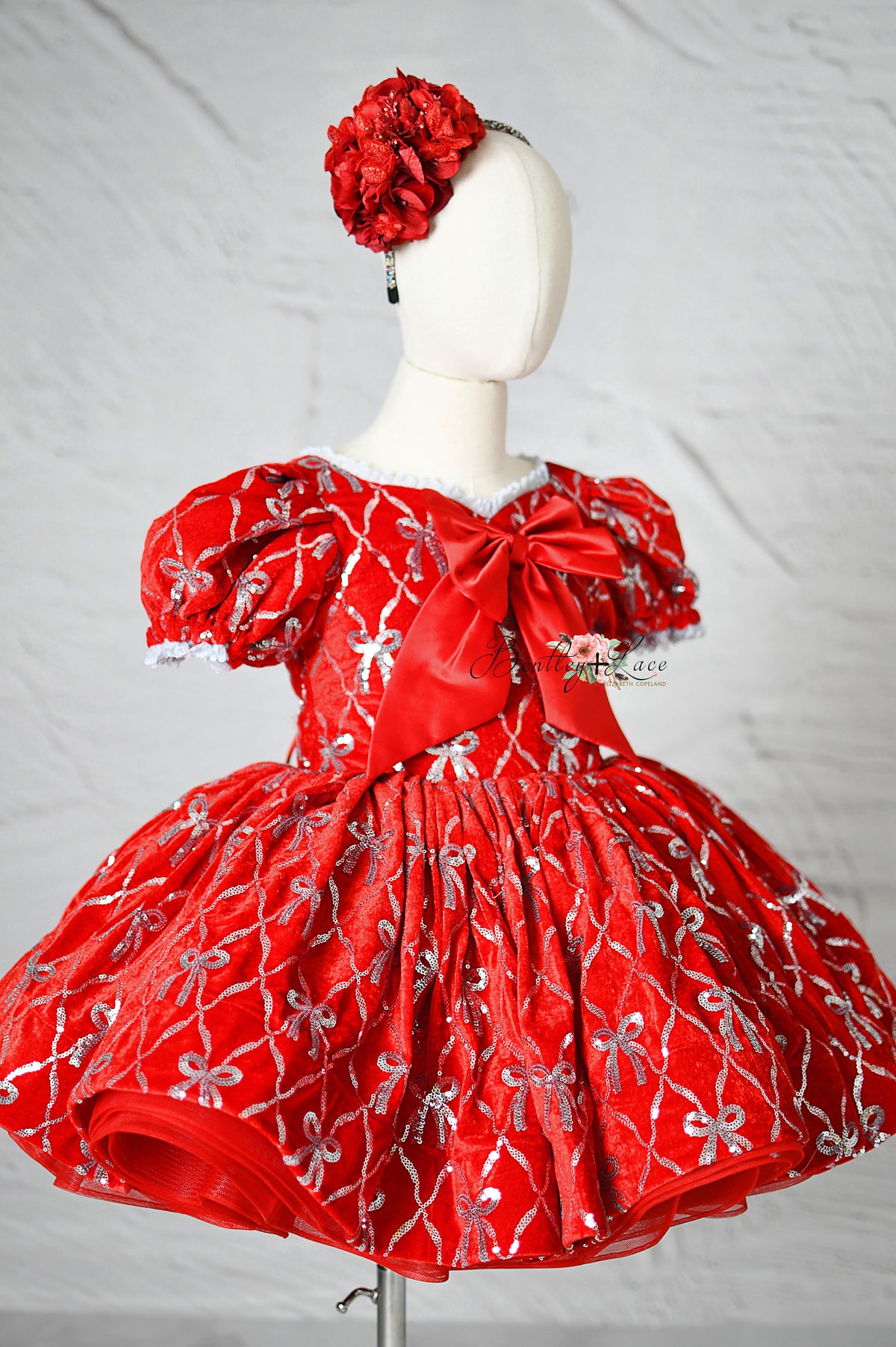 Festive red velvet girl’s gown with shimmering accents ideal for holiday events.

