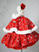 Cape draped over mannequin showcasing fur trim and festive elegance.

