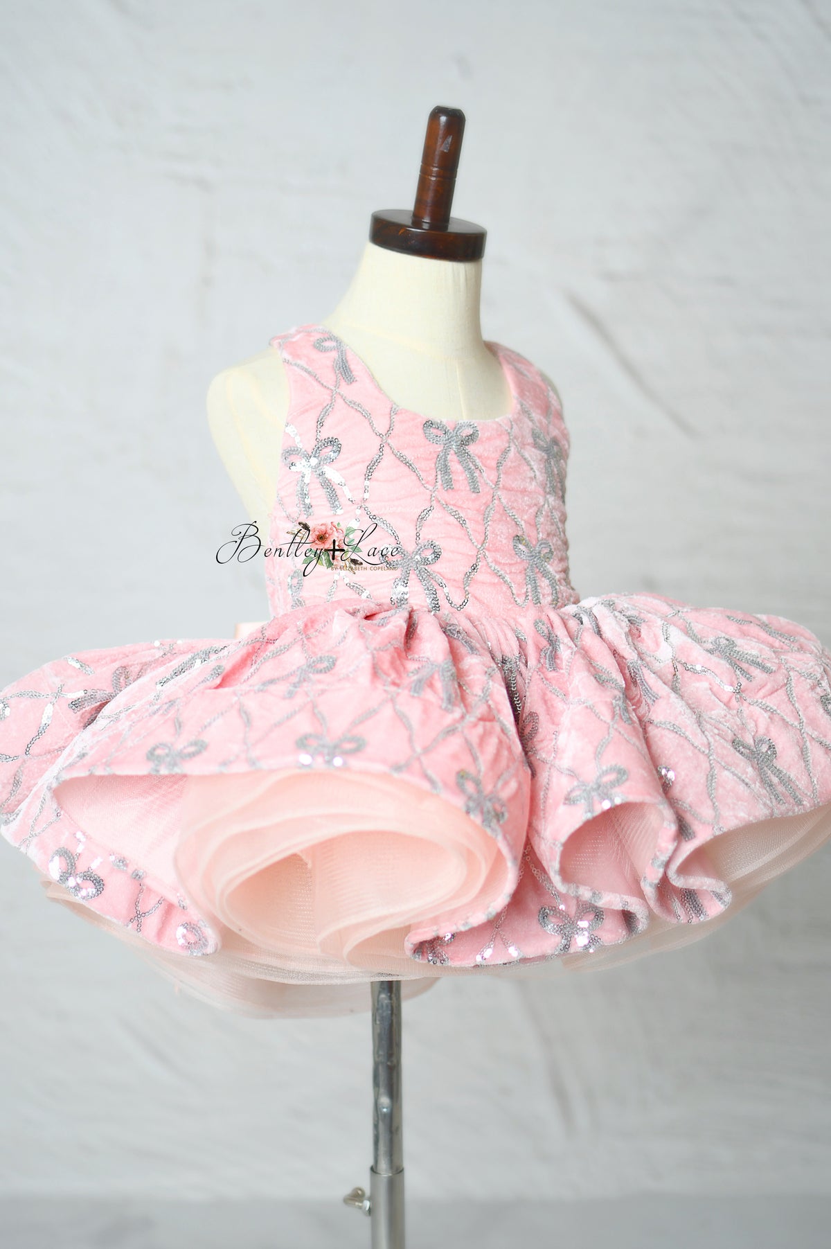 "Girls pink pageant dress with detailed bow embroidery"

