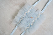 A pair of blue tulle wristlets with bead embellishments.