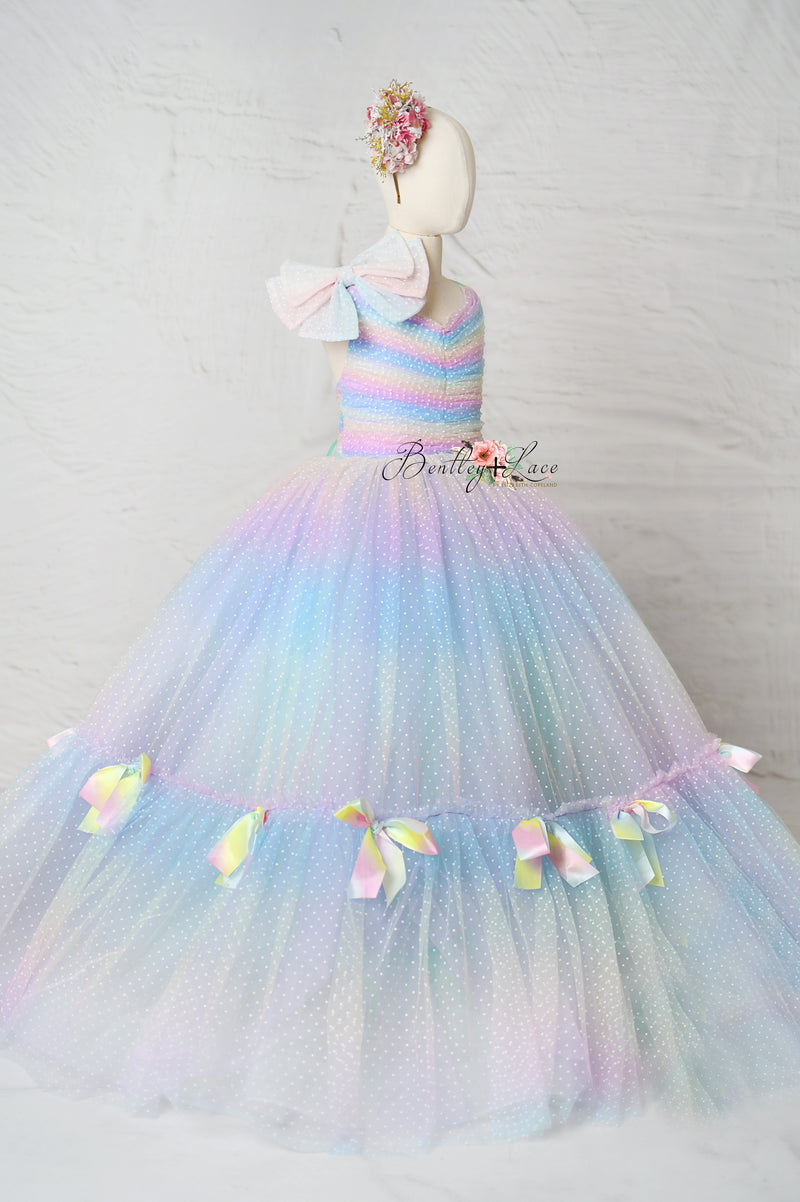 Close-up of the Colorful Bliss Gown’s rainbow swiss dot fabric, capturing its whimsical texture and vibrant, joyful color palette.

