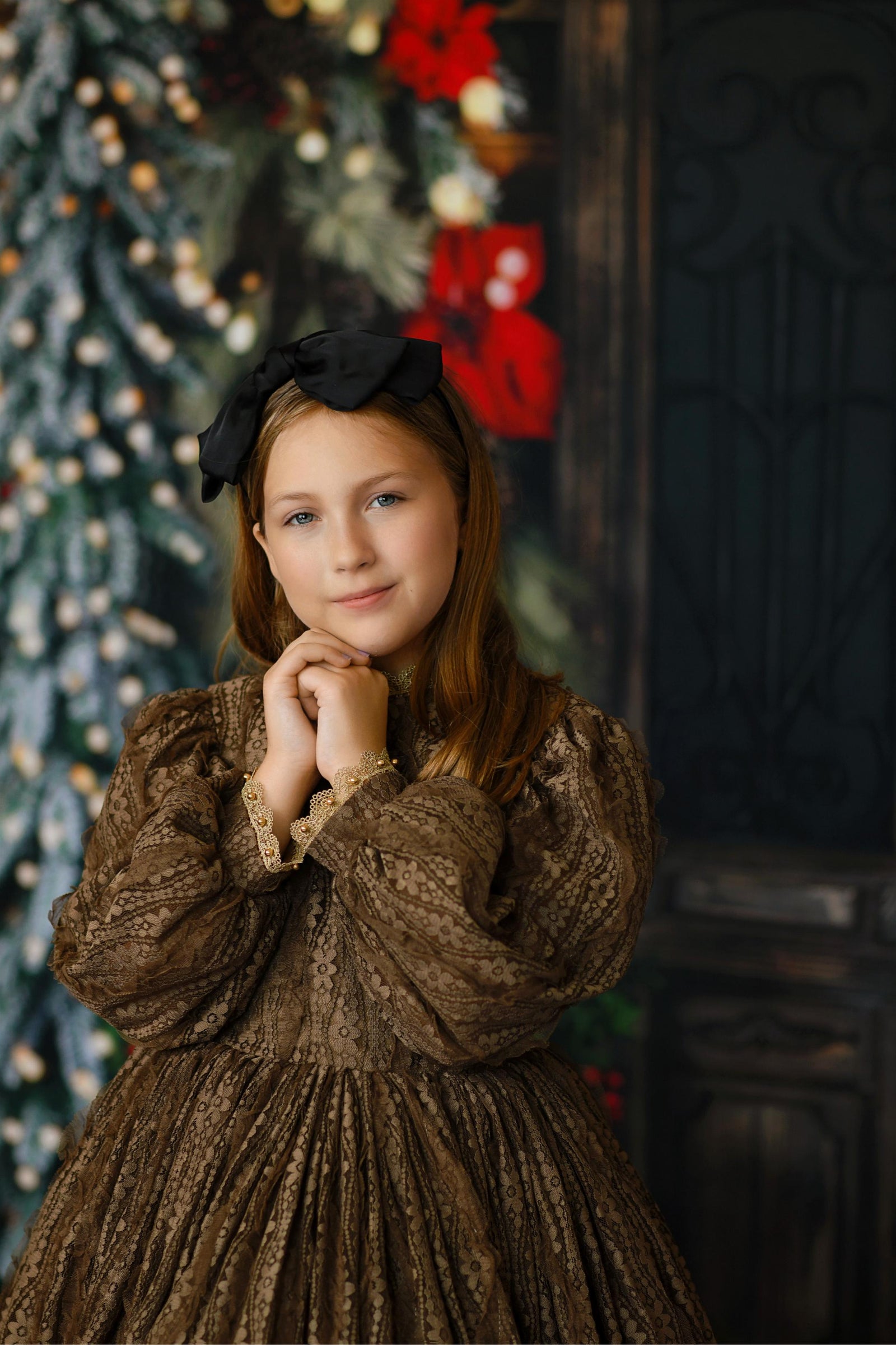 Editorial holiday portrait of a girl in the Serenade gown featuring a keyhole back, zip skirt closure, and intricate lace design.

