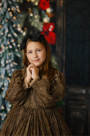 Editorial holiday portrait of a girl in the Serenade gown featuring a keyhole back, zip skirt closure, and intricate lace design.

