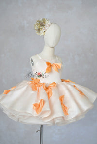 “Elegant flower girl dress with soft floral headpiece and clementine bows”

