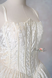 Shows the gown’s side structure and flow while giving a flattering view of the model.

