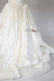 Gown displayed on dress form with soft studio lighting

