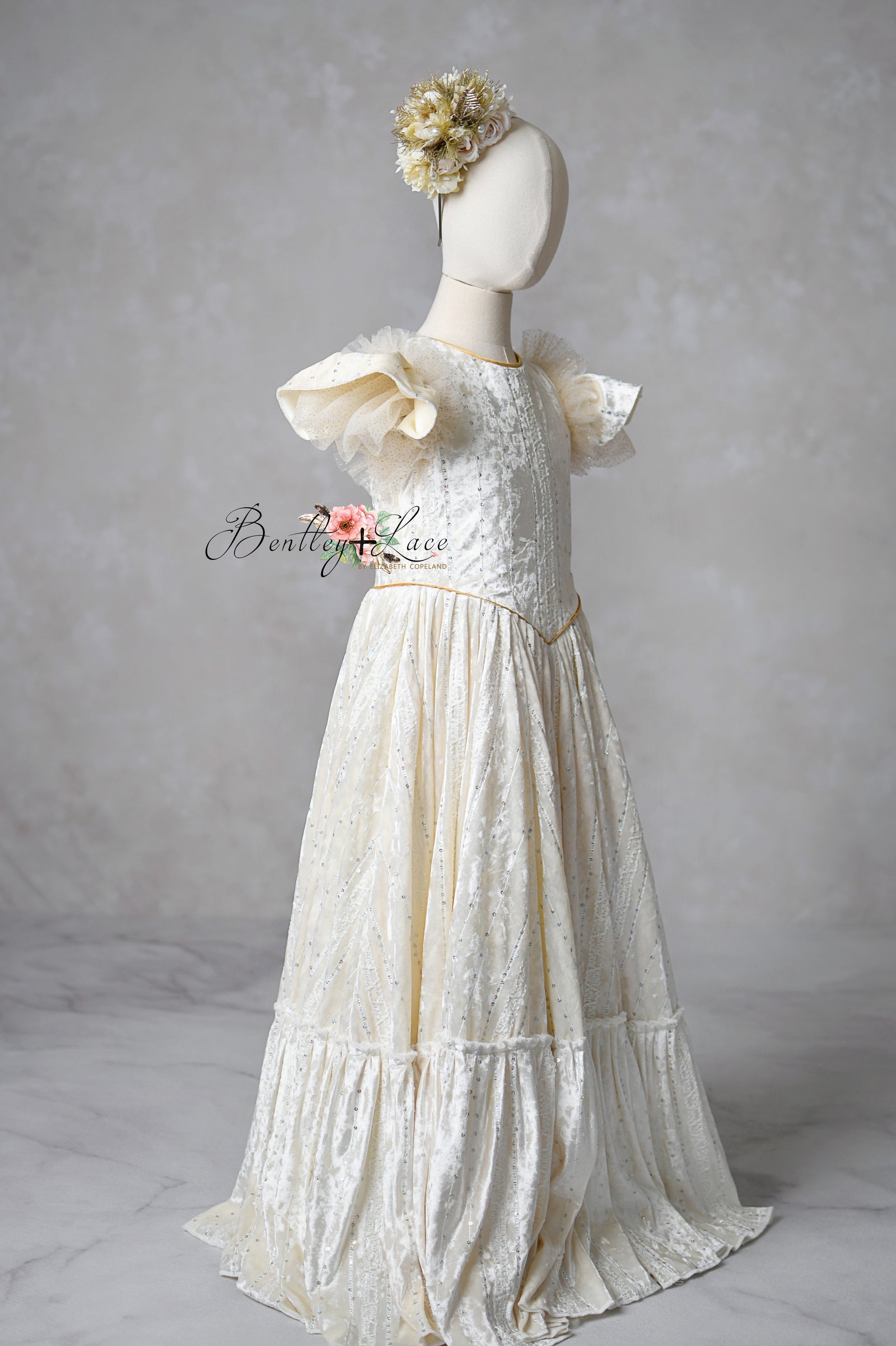 Child wearing Clara’s Dream ivory floor-length gown with detachable bow

