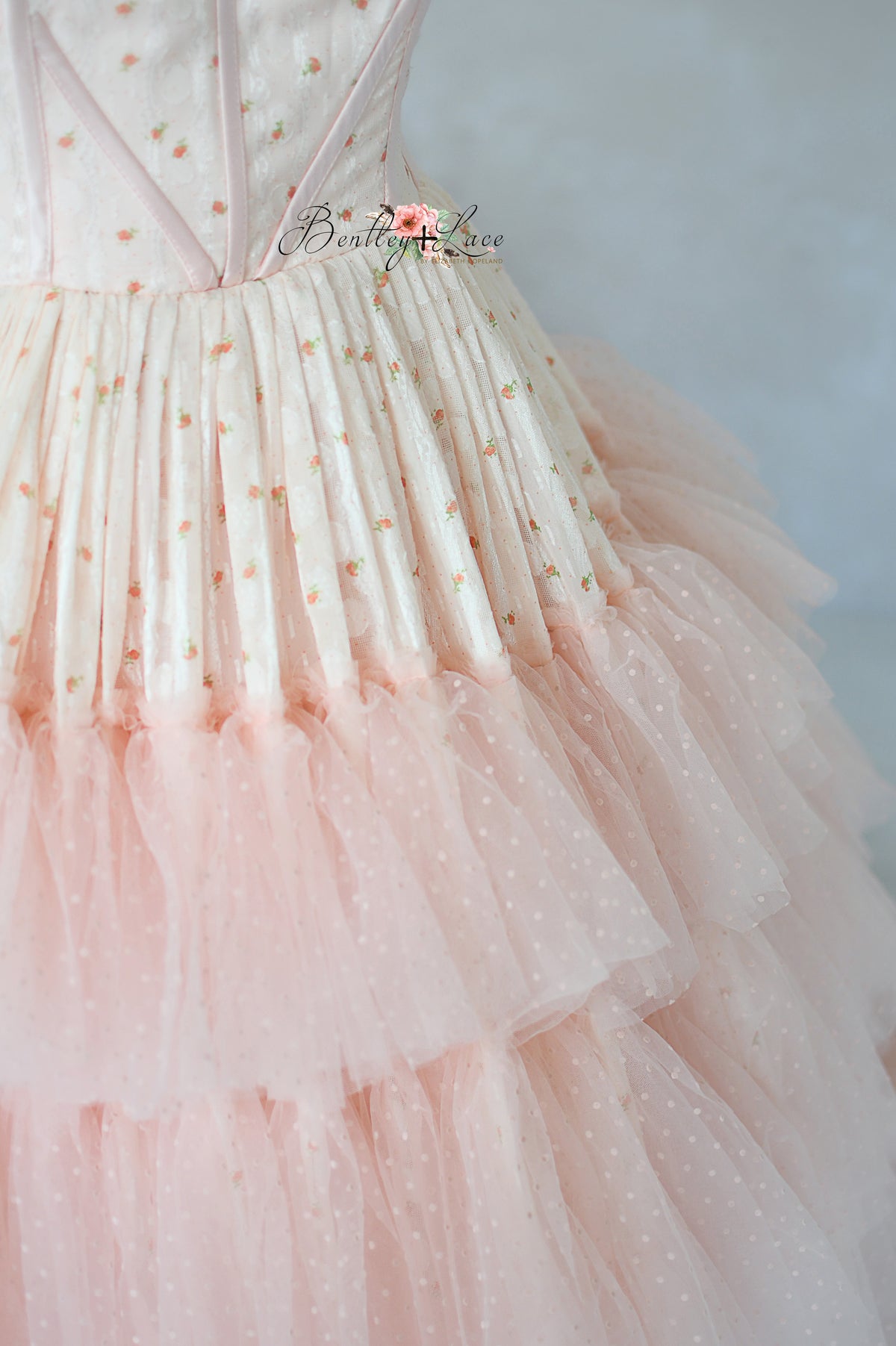 Pink couture gown with layered skirt, ideal for photoshoots and events.

