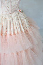 Pink couture gown with layered skirt, ideal for photoshoots and events.


