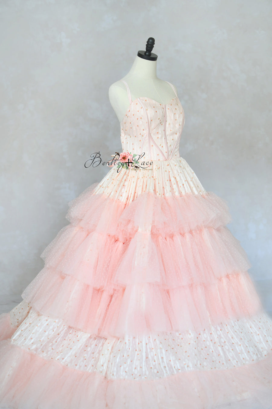 Romantic pink gown with structured boned bodice and flowing chiffon skirt.

