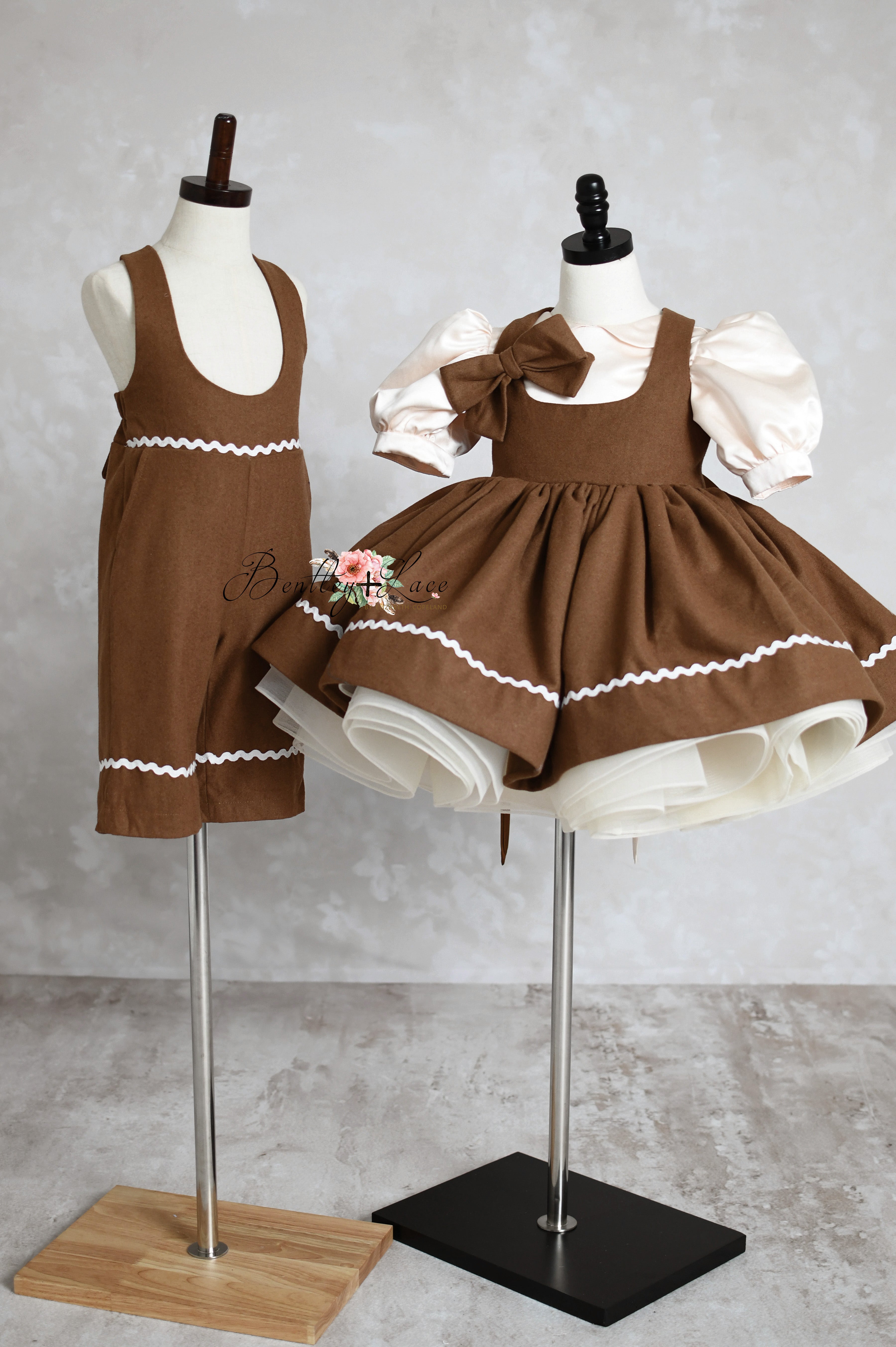 Image of a charming holiday dress featuring a removable gingerbread-themed apron, adjustable shoulder ties, and an elastic waistband. The dress offers customizable options such as petal or puff sleeves, perfect for festive occasions and holiday photography sessions.