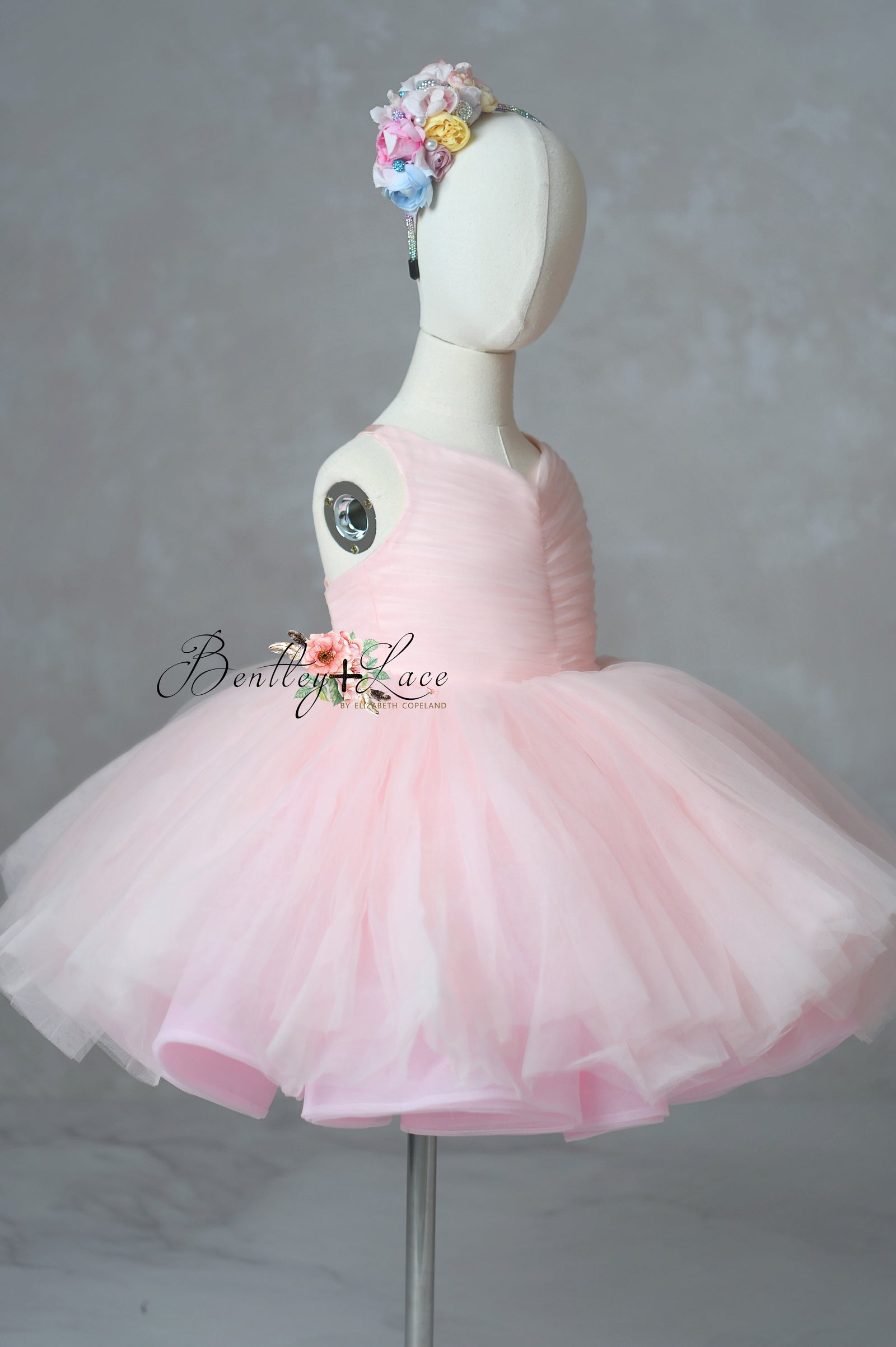 Pink tutu dress on a mannequin with a gray background