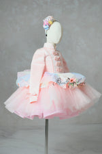 Mannequin wearing a pink dress with floral accents on a gray background