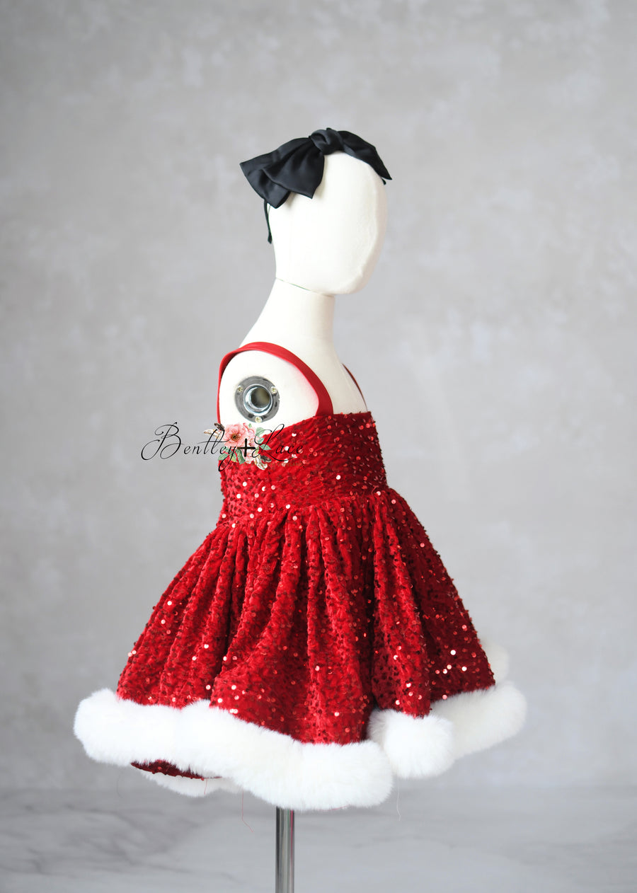 Red sequin dress with white trim on a mannequin against a gray background