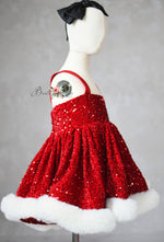 Red sequin dress with white fur trim on a mannequin against a gray background