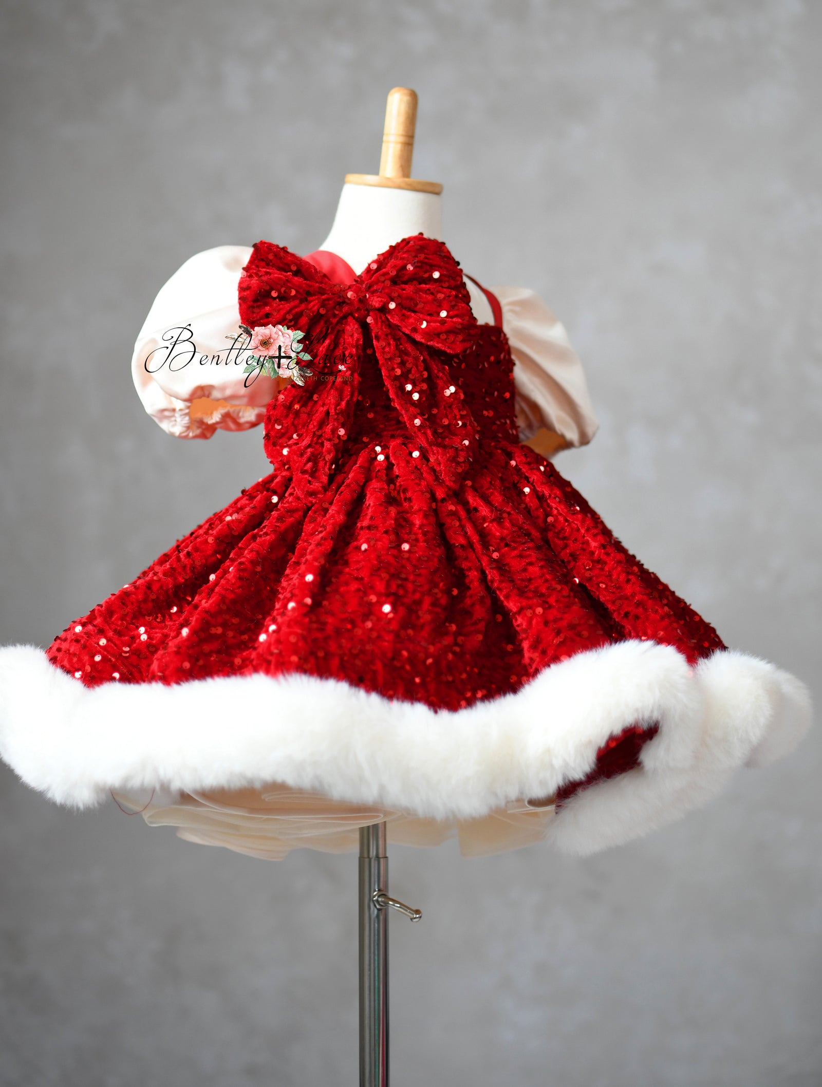 Festive sequin dress paired with velvet hair bow accessory.

