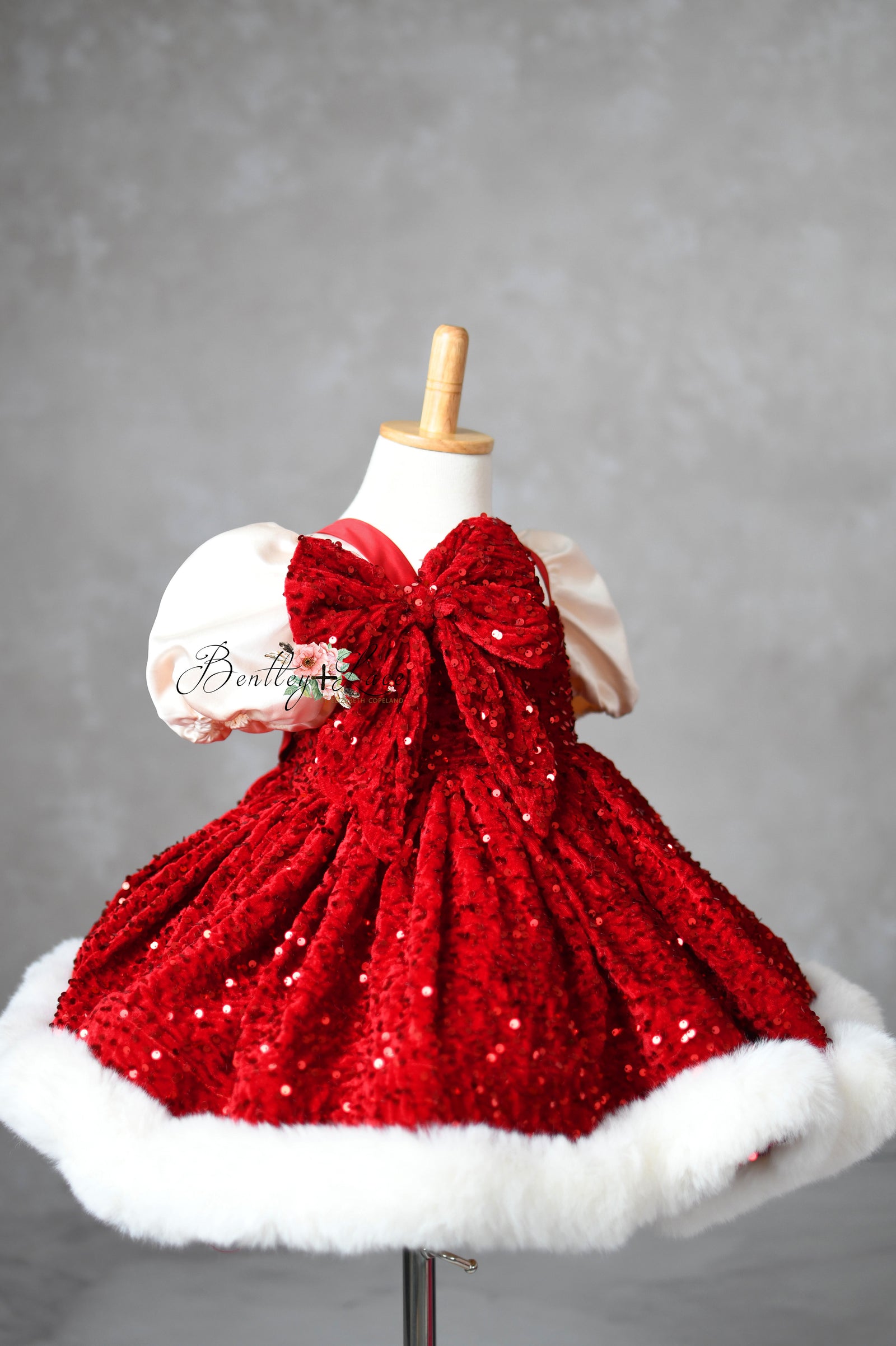Holiday dress featuring detachable oversized bow and fur hem.

