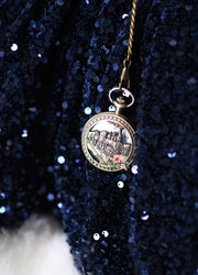 Decorative keychain with a circular design on a blue textured background