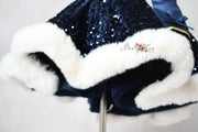 Navy blue sequin dress with white fur trim on a light gray background