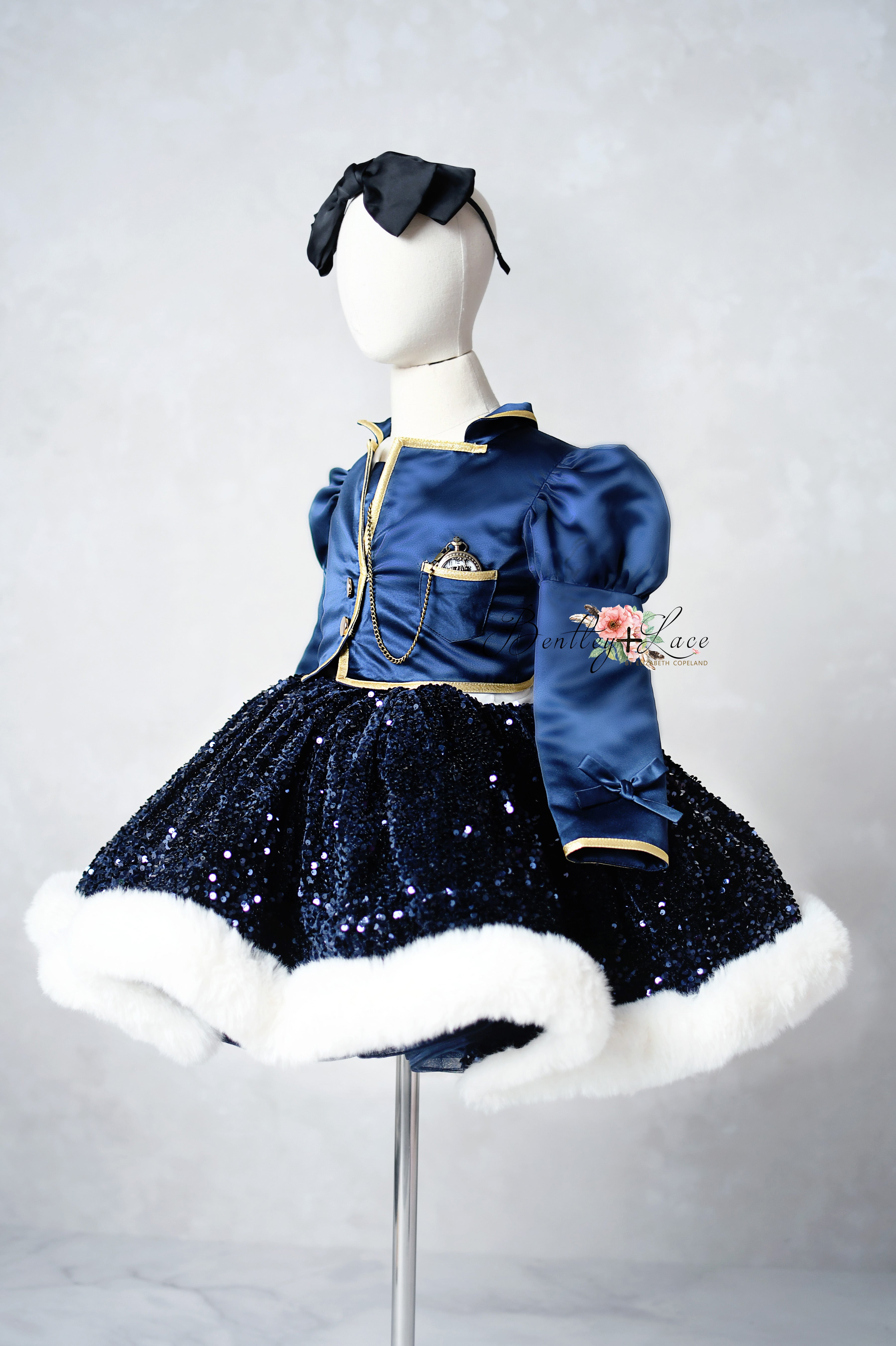 Mannequin wearing a blue dress with white fur trim on a plain background