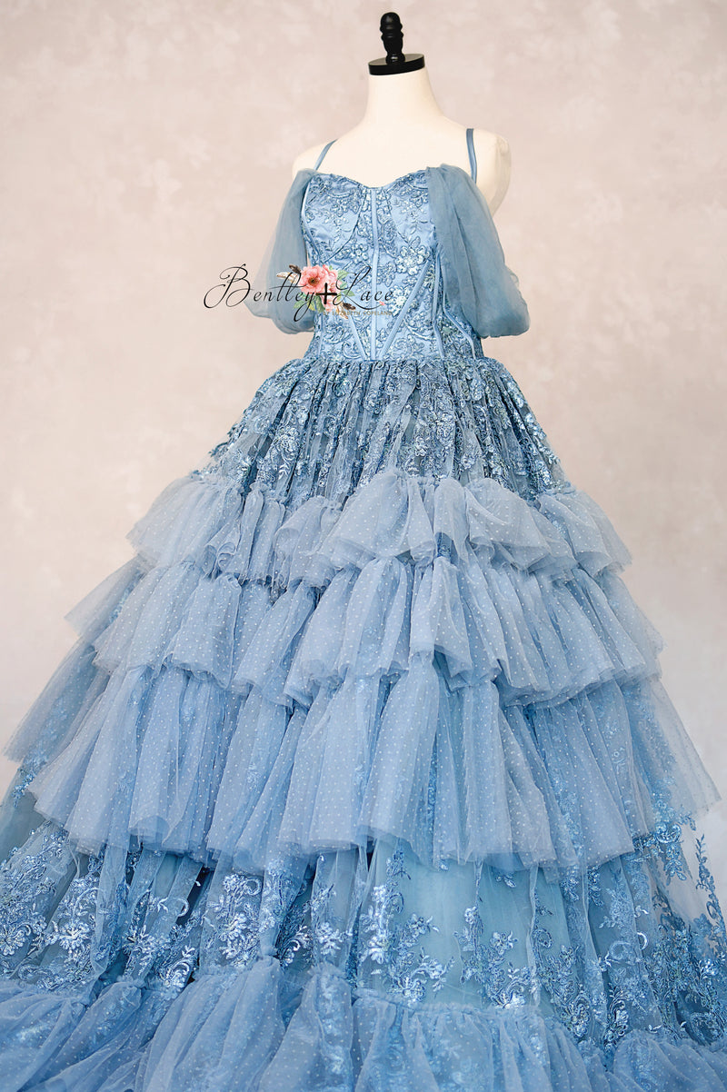 Blue ball gown on a mannequin against a plain background