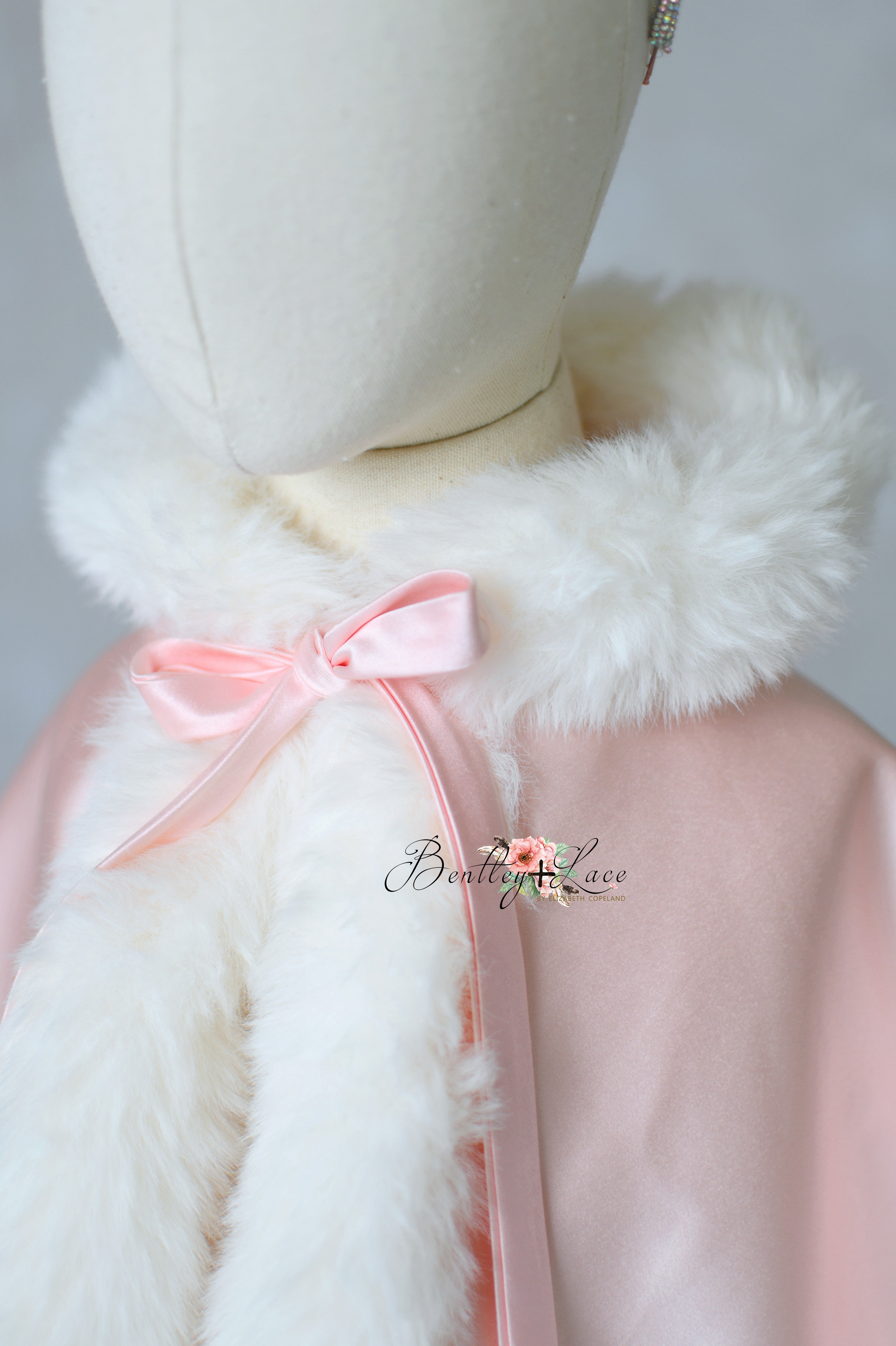 Pink coat with white fur collar on a mannequin, featuring the brand 'Bentley Love'.