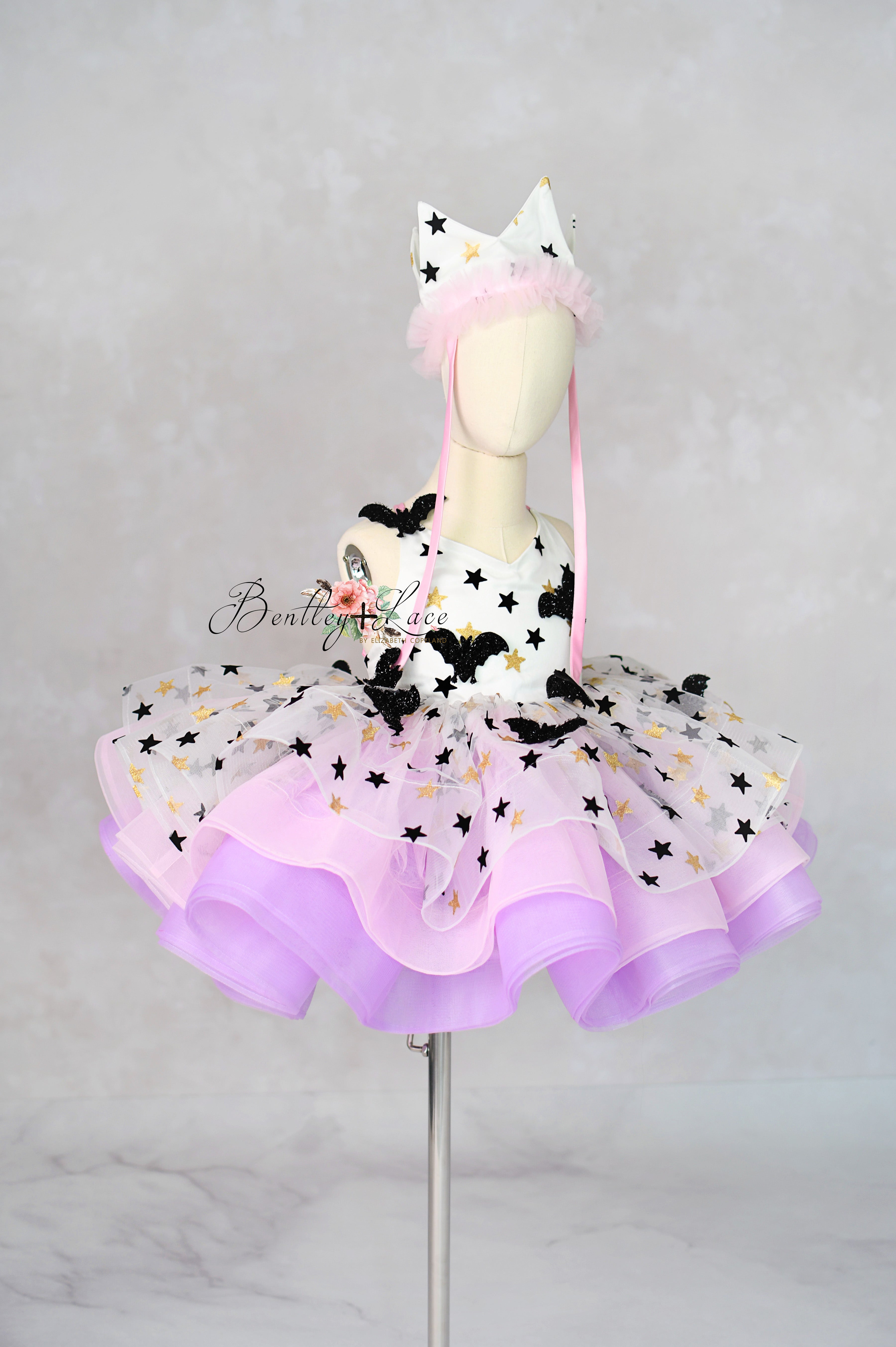 Children's costume with star-patterned skirt and headband on a mannequin against a gray background