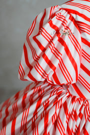 red and white striped Candy Cane Lane Dress for a Christmas photo session.