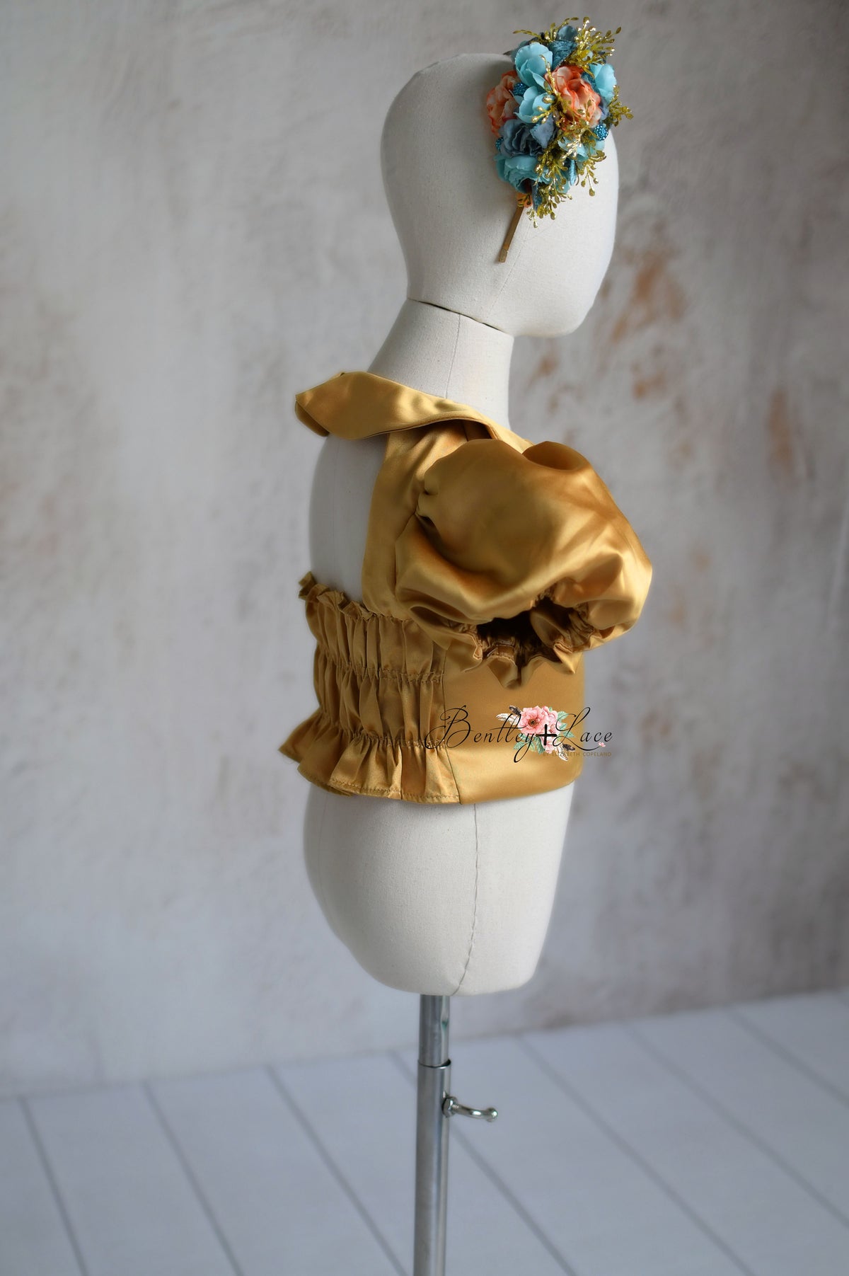 Close-up of satin bodice and floral accents on the Golden Belle dress.