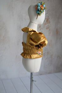 Close-up of satin bodice and floral accents on the Golden Belle dress.