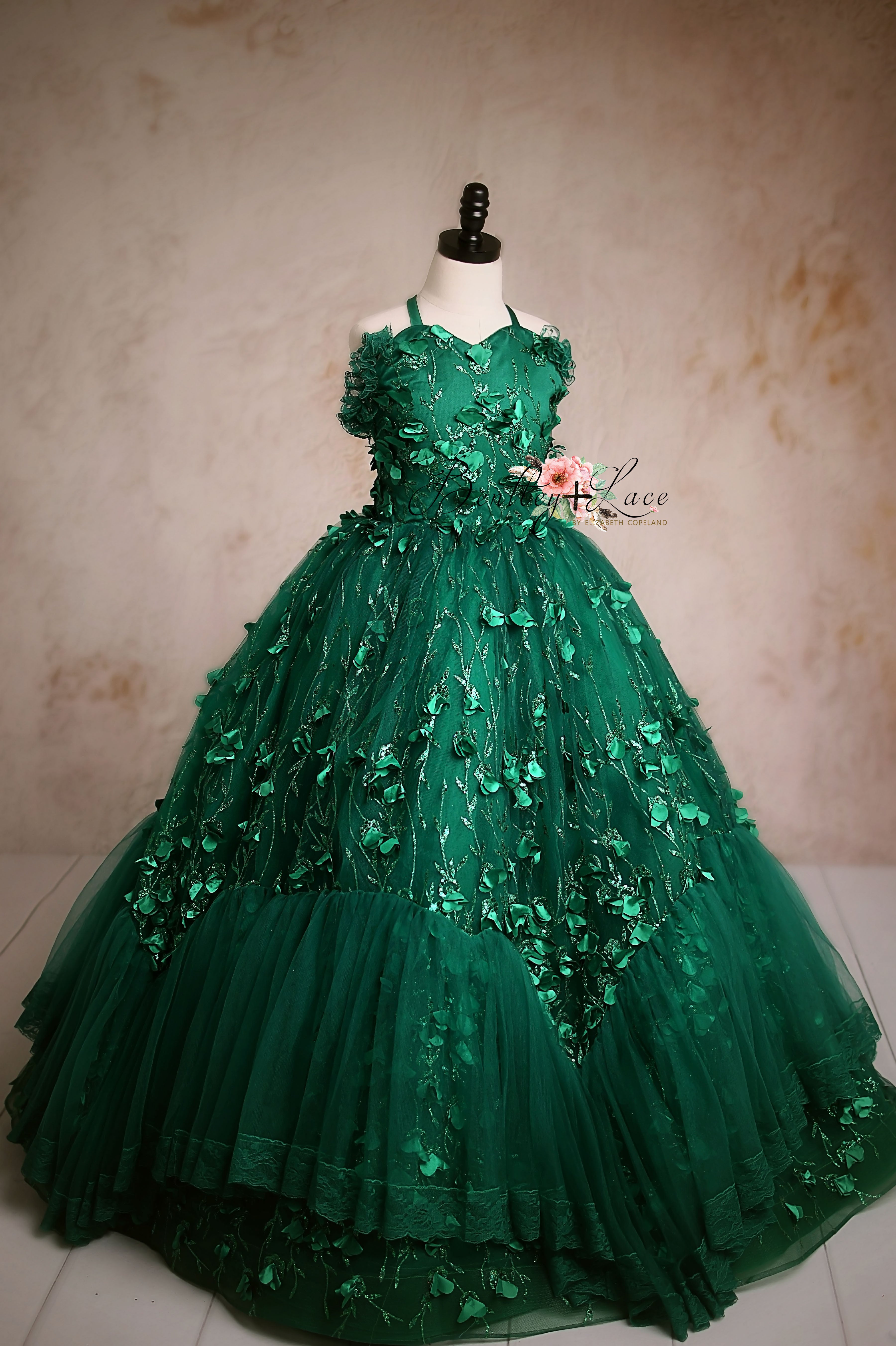 Elegant green ball gown with floral embellishments and a tulle skirt.