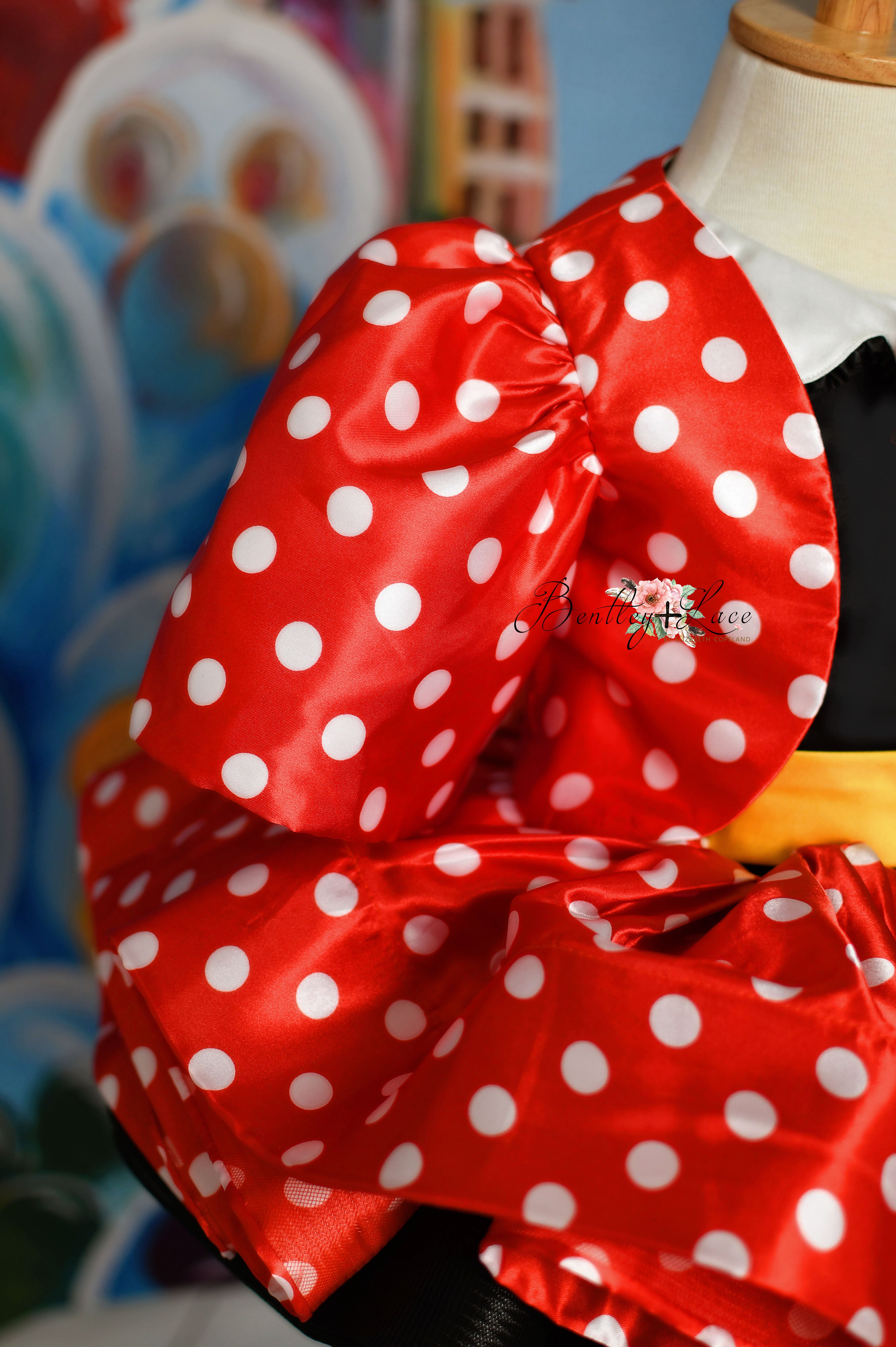 Detailed shot of the "Miss Mouse" dress's bodice with a cute Minnie-inspired bow and polka dot pattern.